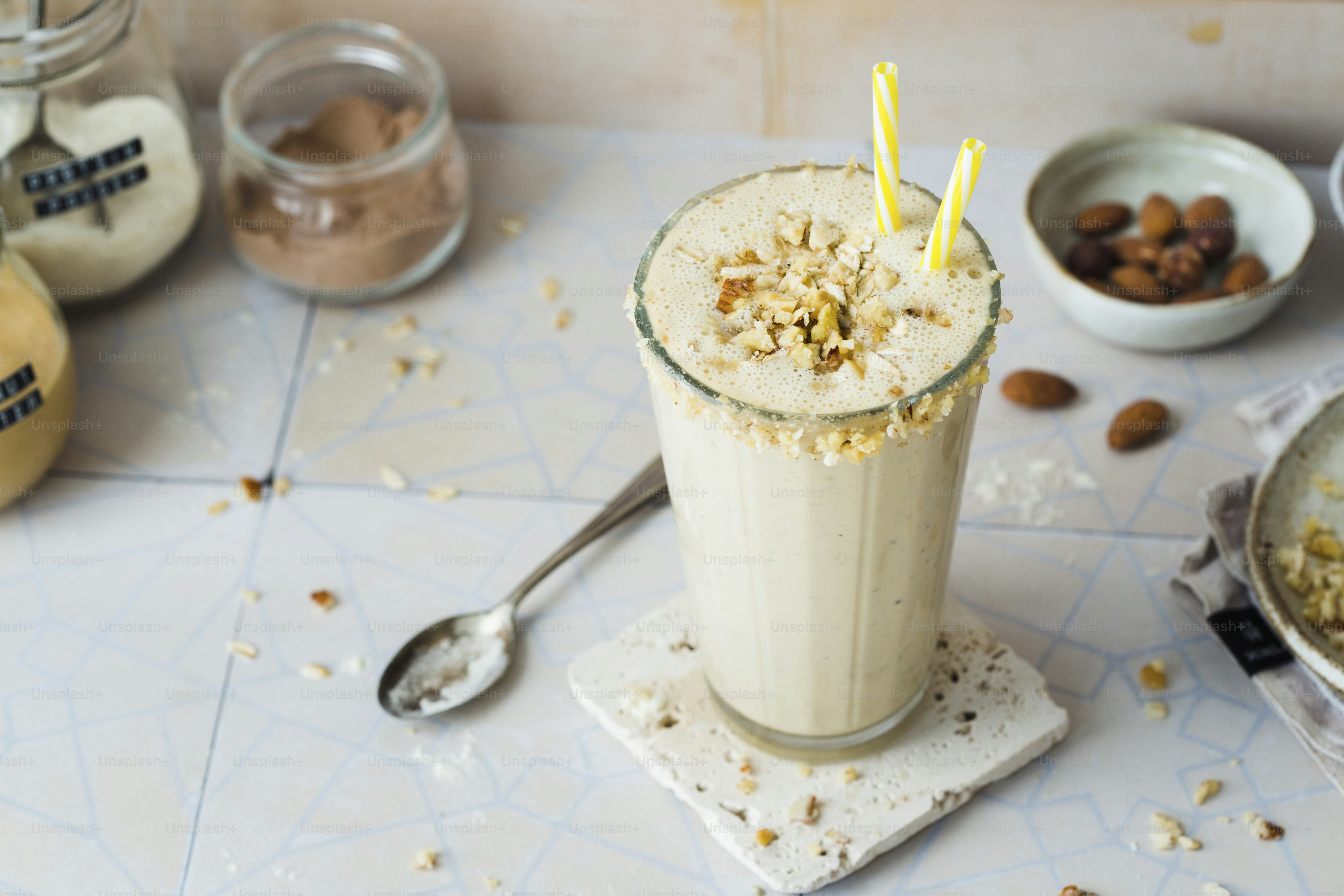 A milkshake with a straw and a spoon on a table