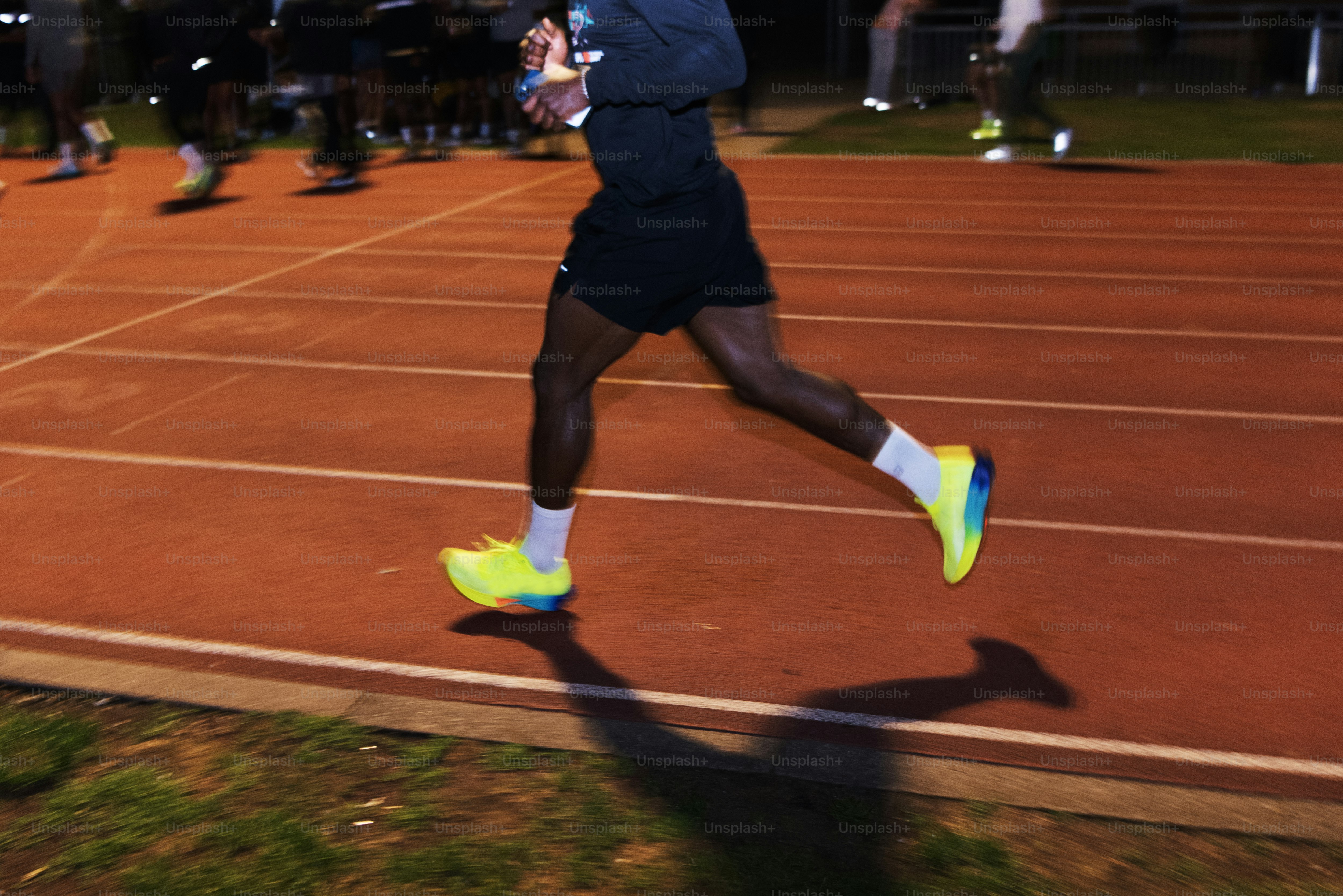 Un homme courant sur un court de tennis la nuit