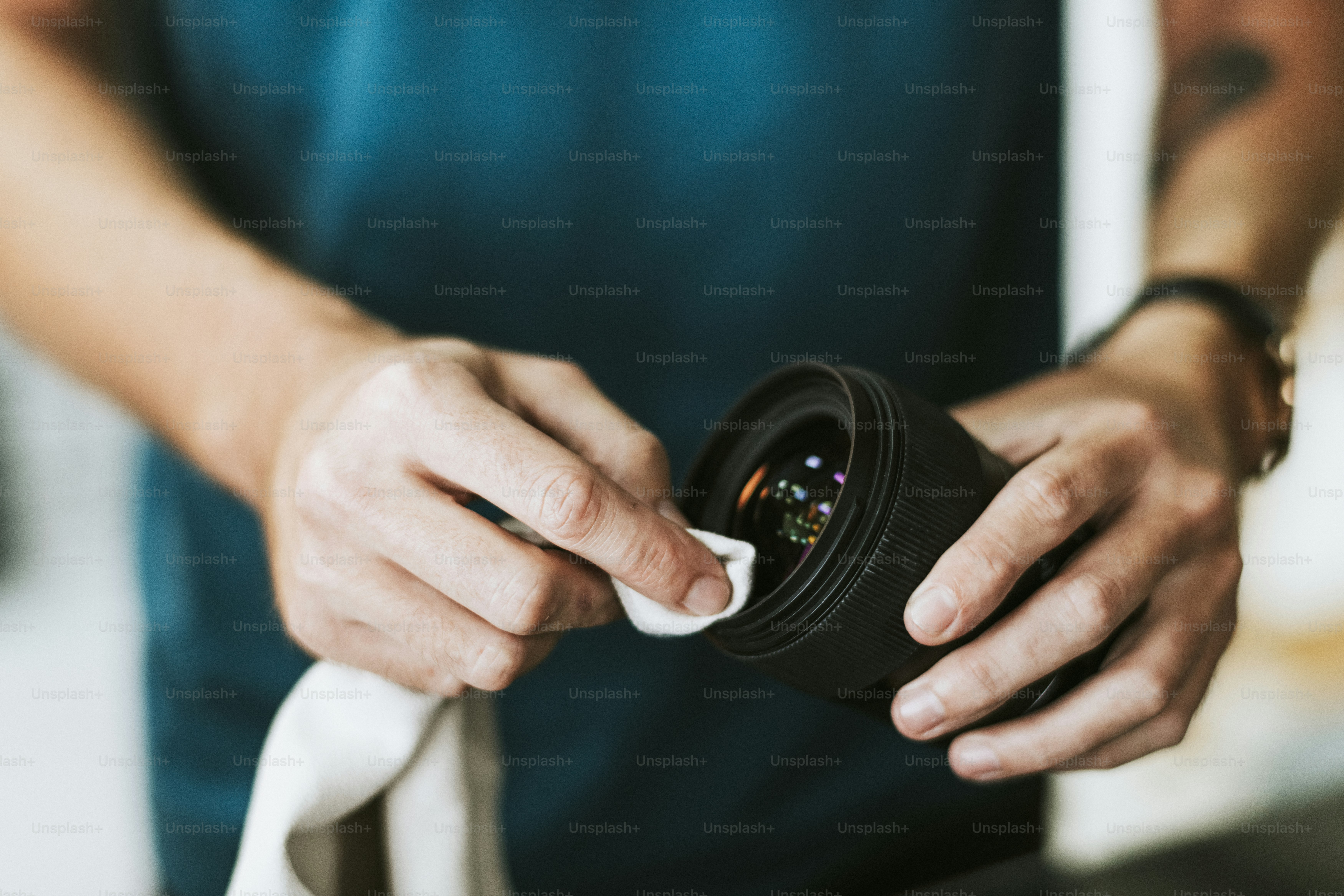 Photographer assistant cleaning a lens