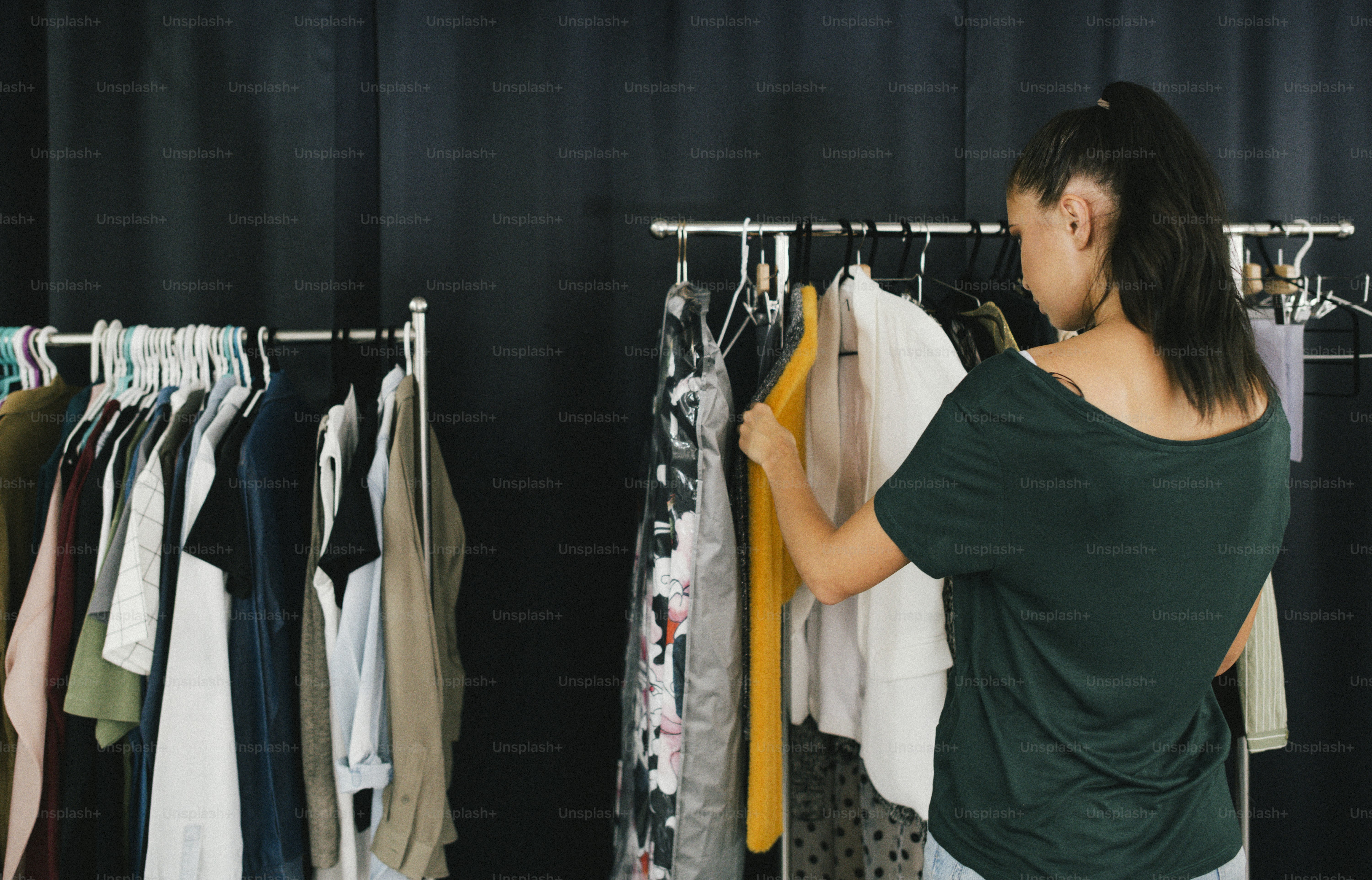 Modèle choisissant une tenue sur le porte-vêtements