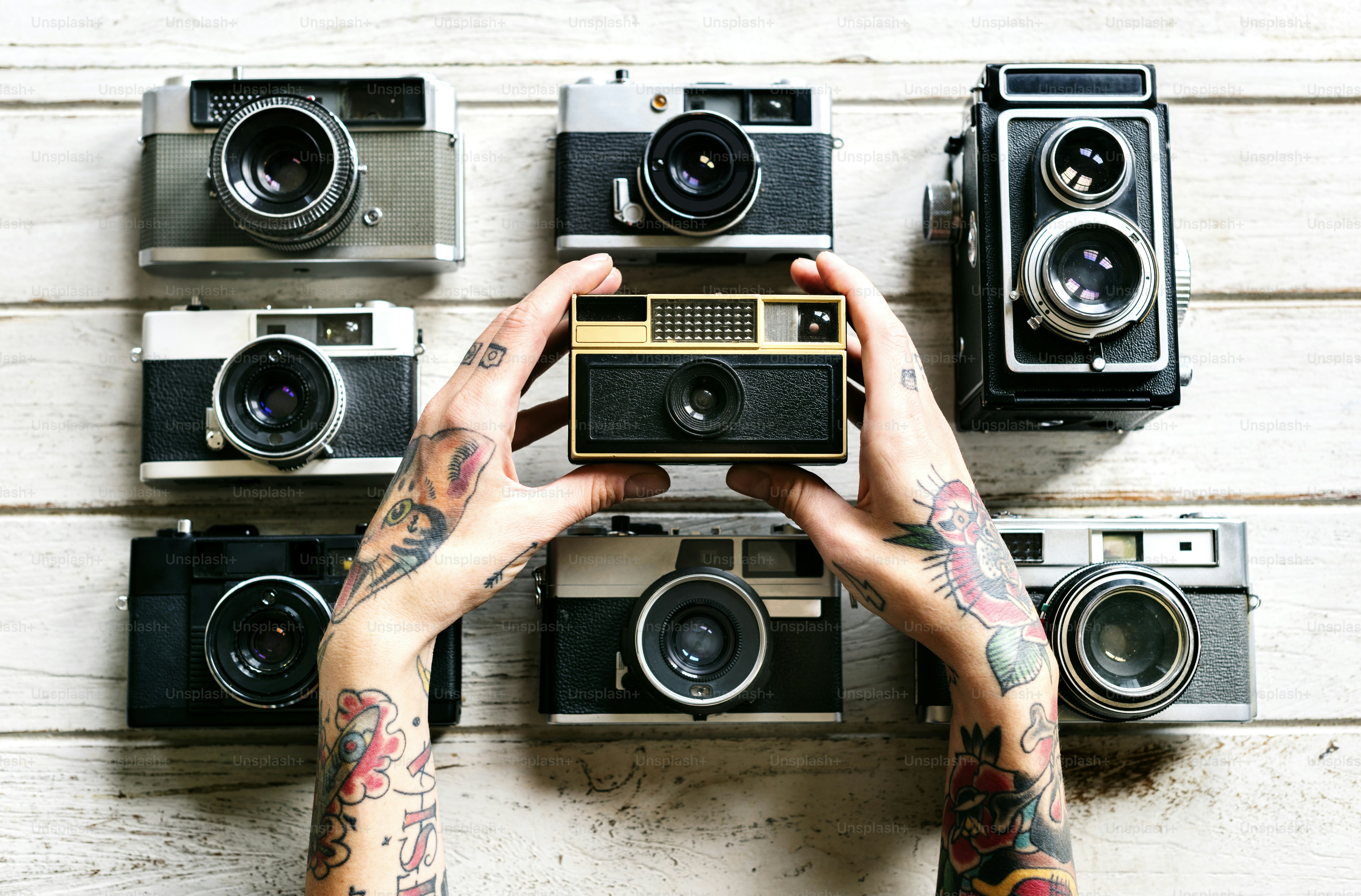 Hands with tattoo holding a camera