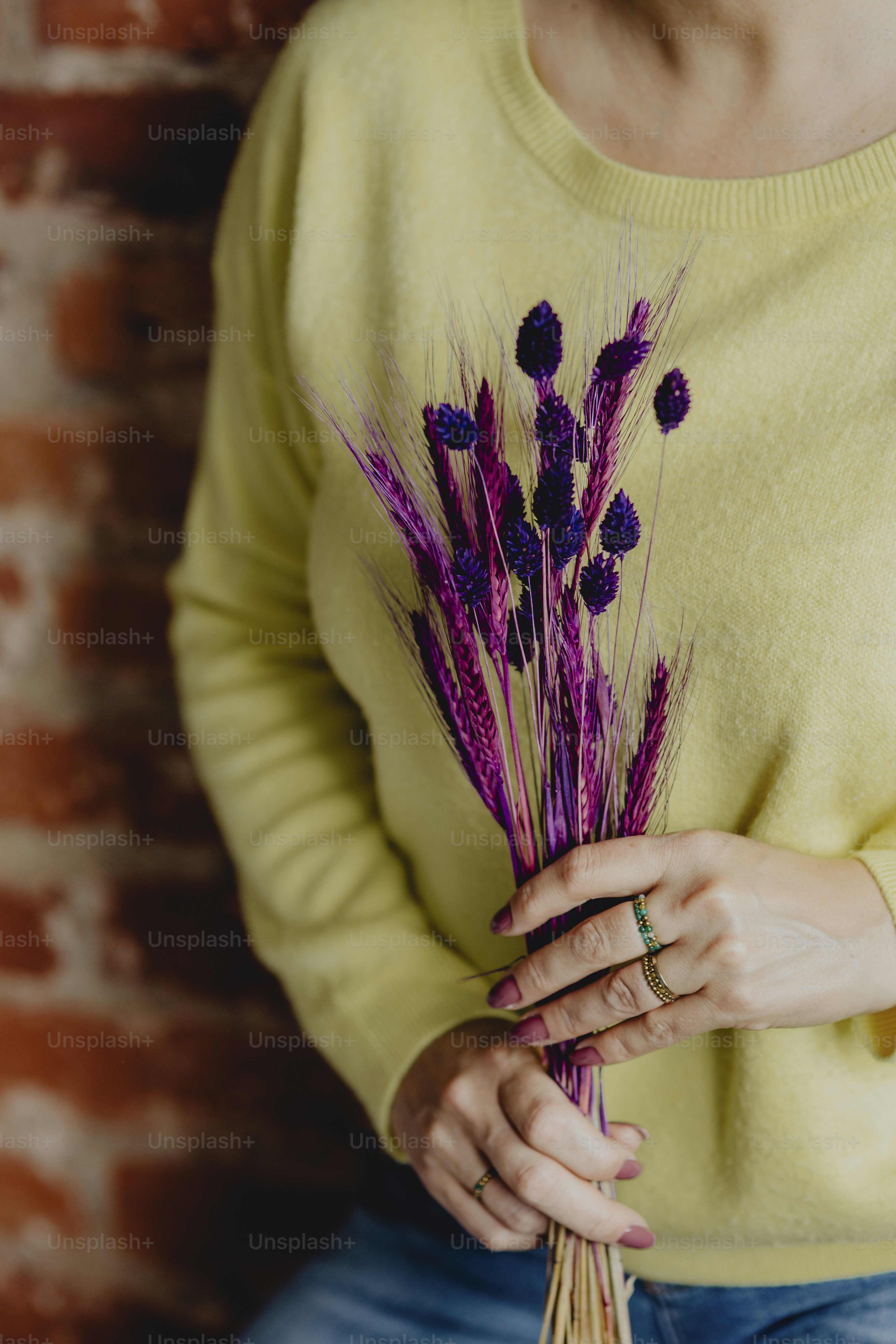 Woman holding a bundle of purple dyed wheat