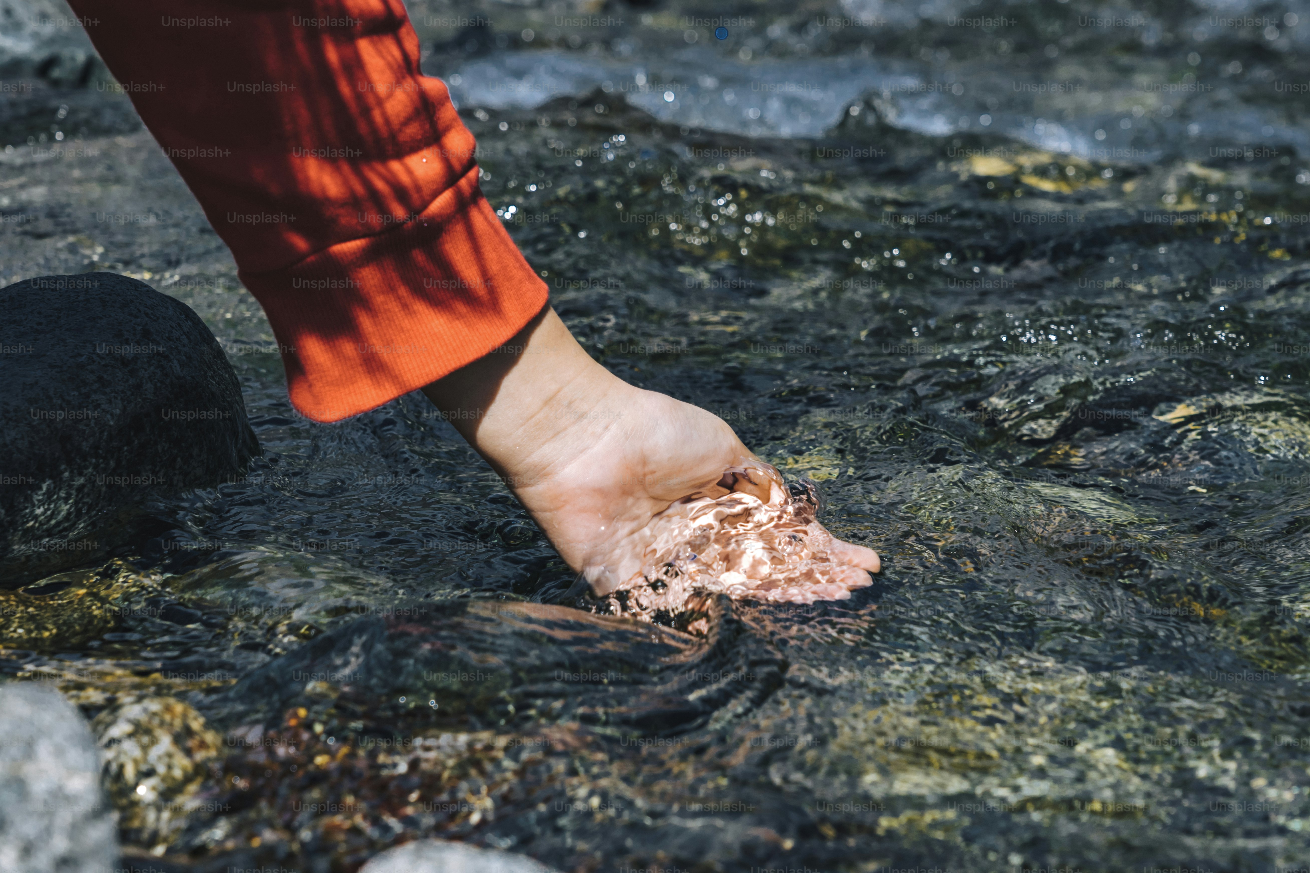 Woman scooping up water from the valley