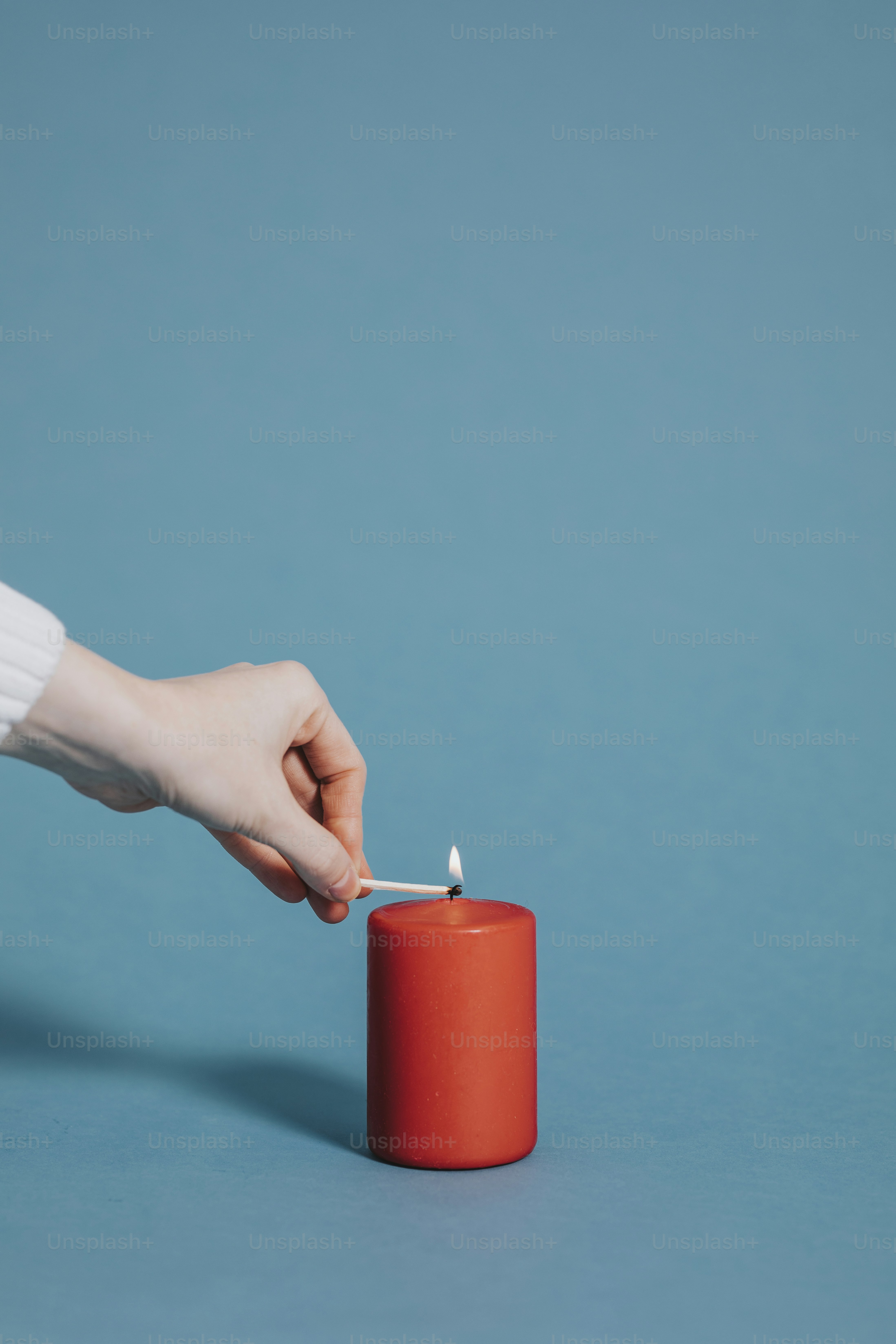 Woman lighting a red candle