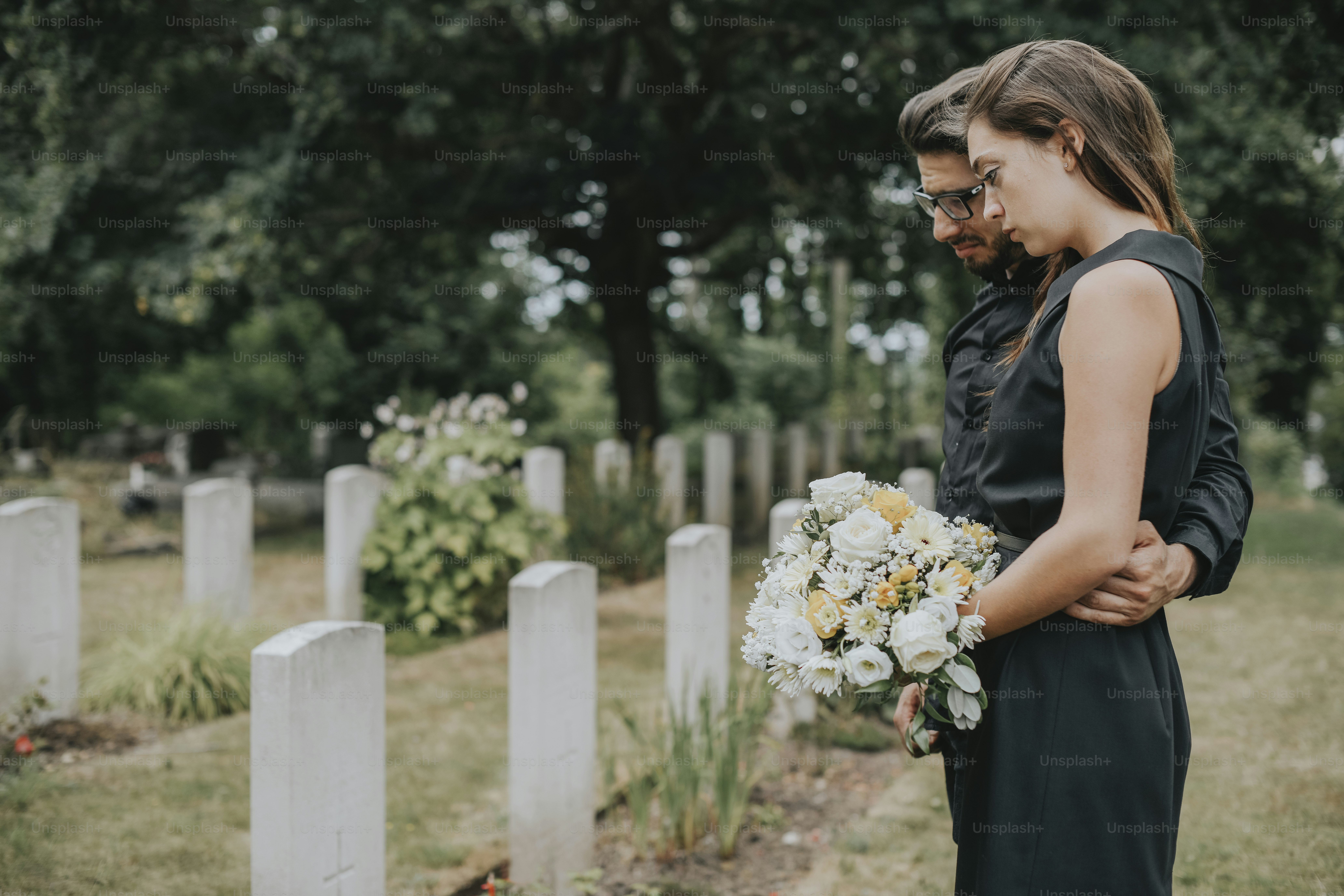 Couple standing together by a gravestone