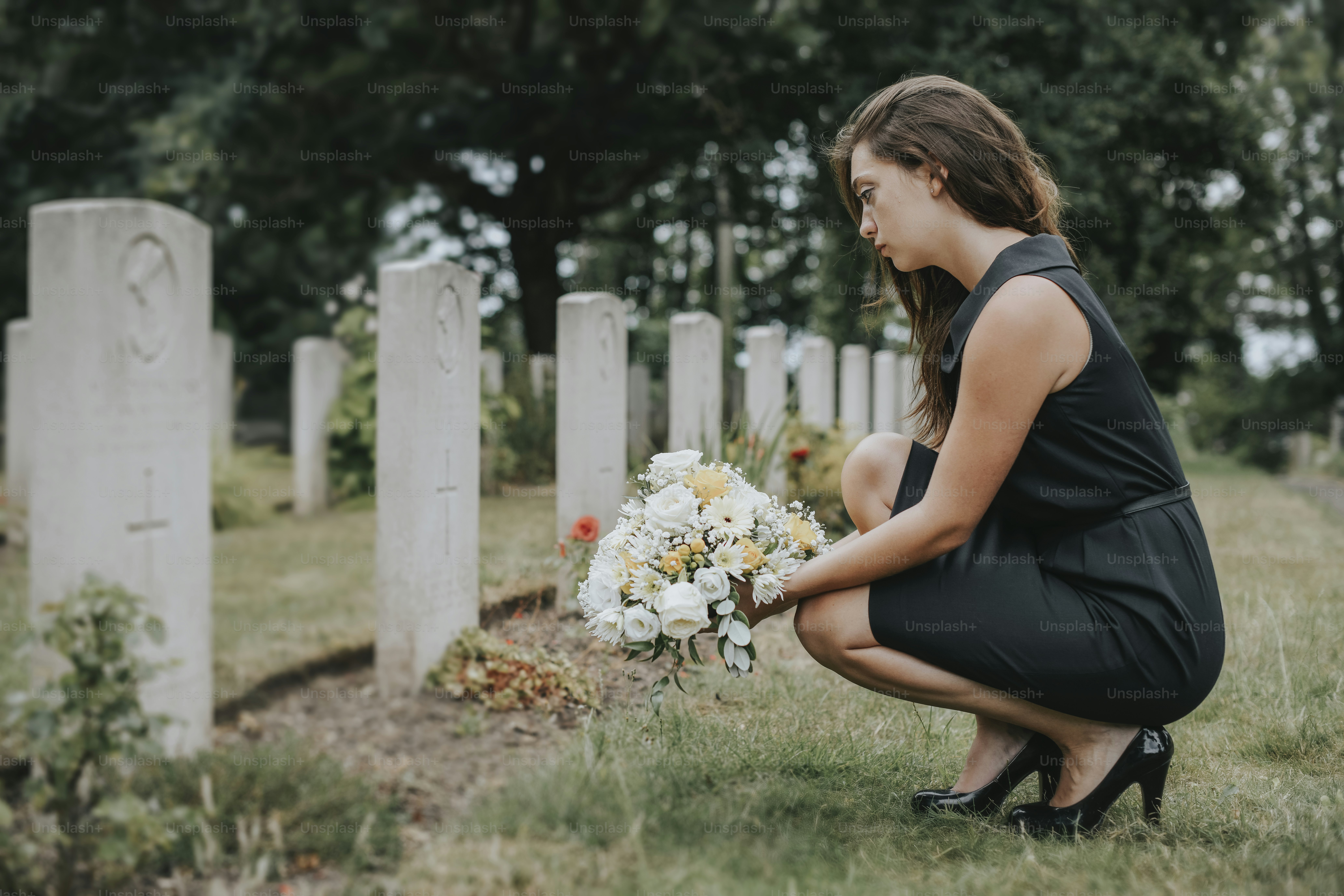 Young widow laying flowers at the grave photo Mourning Image on Unsplash
