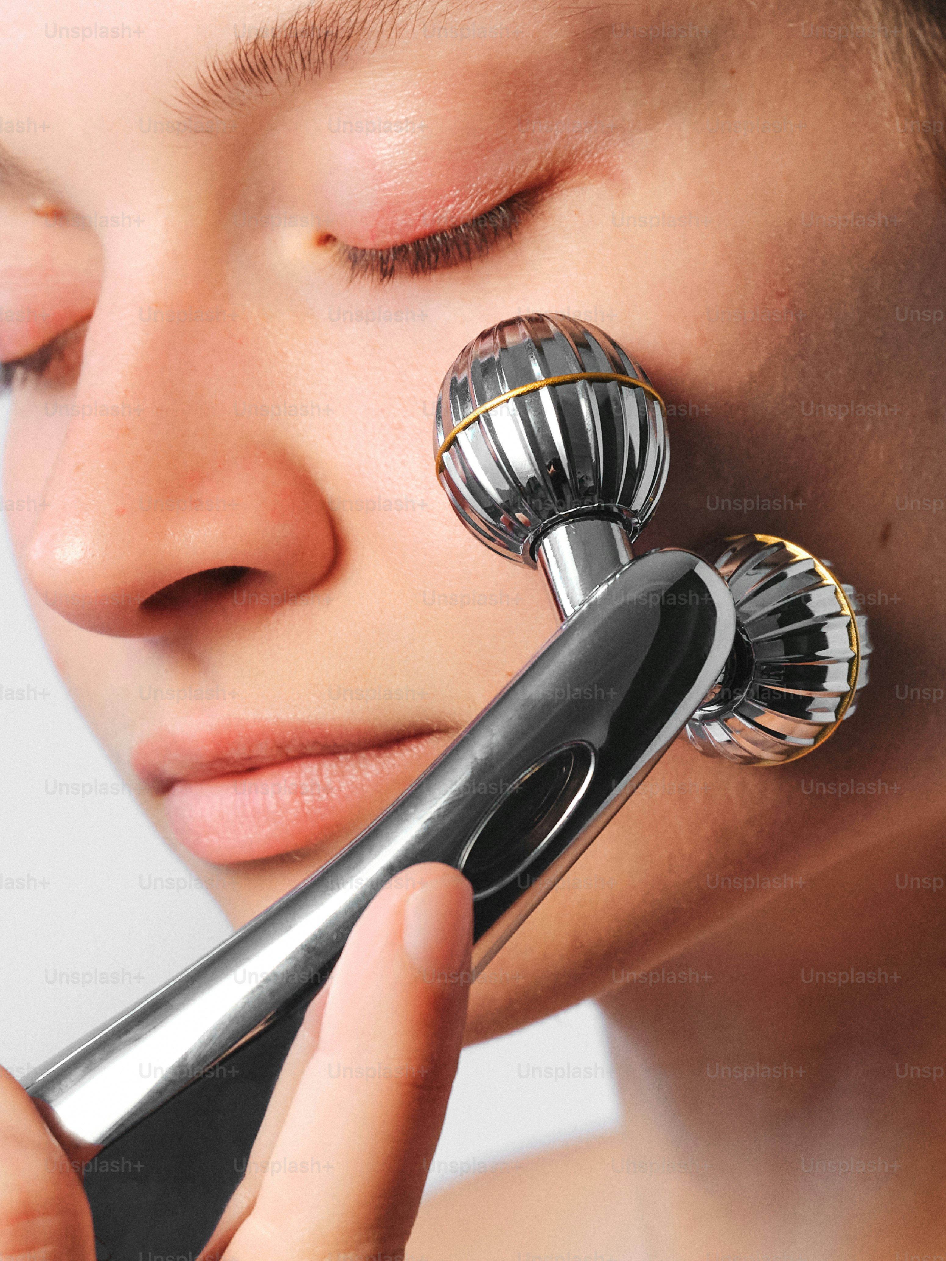 A woman using a hair dryer on her face