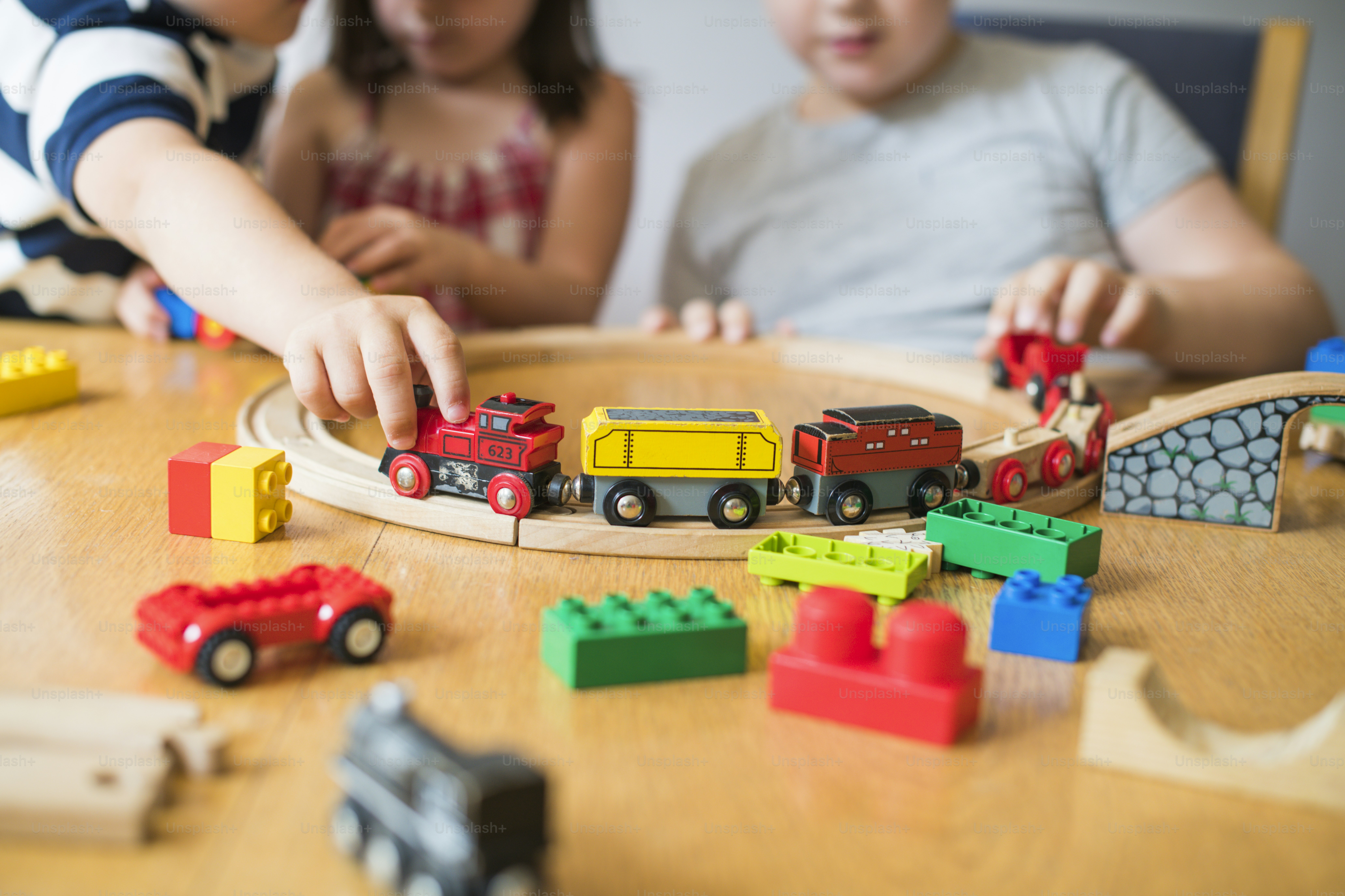 Siblings playing with blocks, trains and cars
