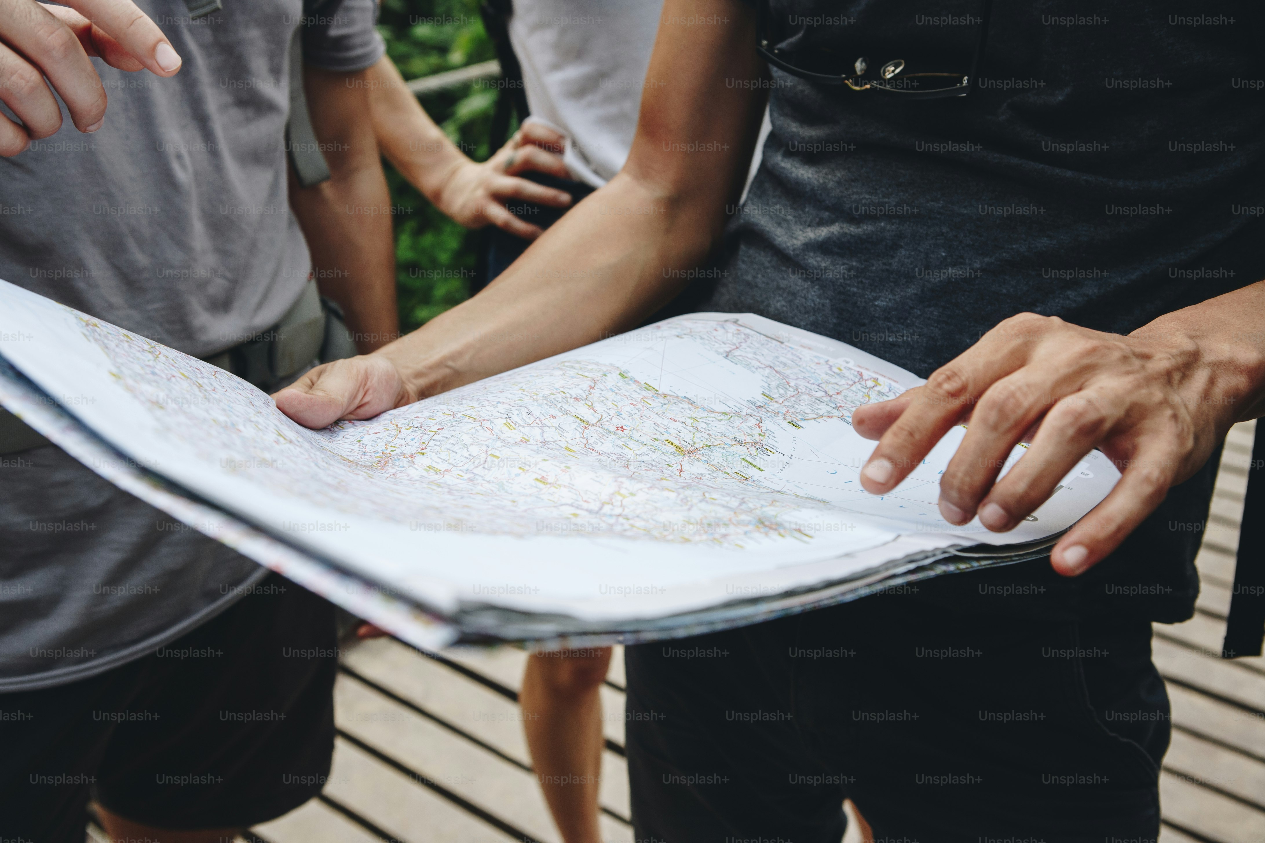Group of friends looking at a map together travel and teamwork concept