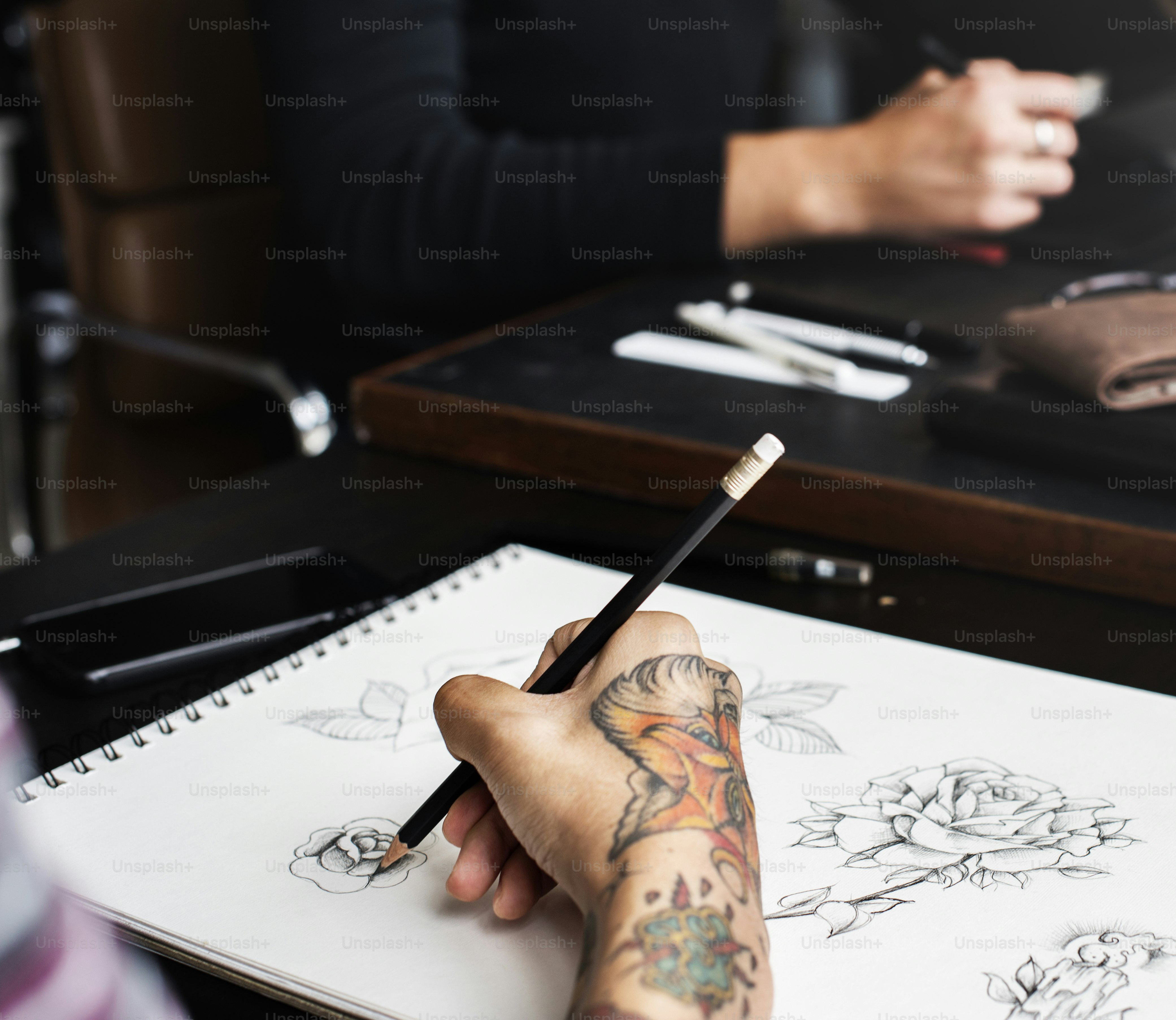 Closeup of tattooed hand with drawing artwork