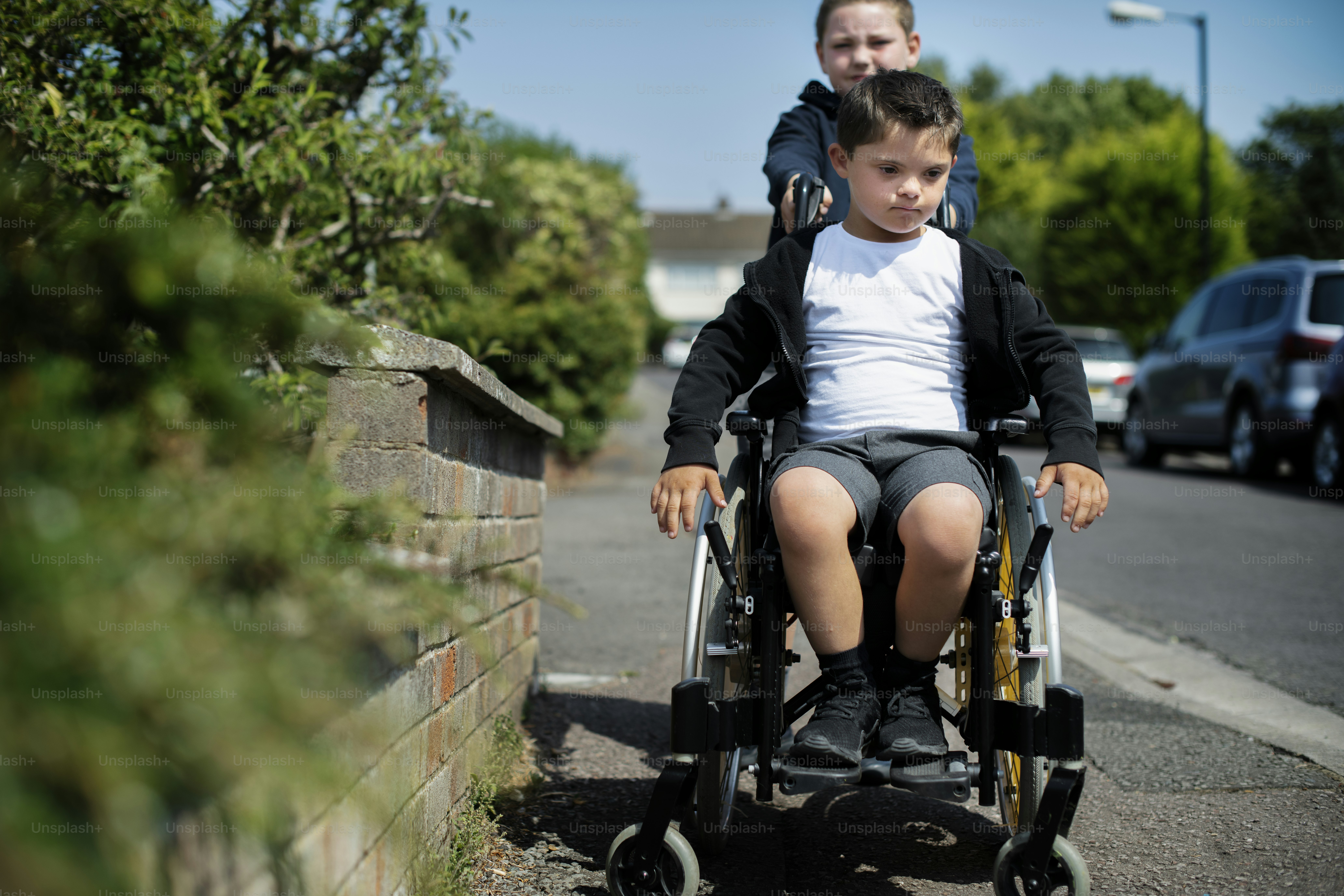Ragazzo che spinge suo fratello su una sedia a rotelle