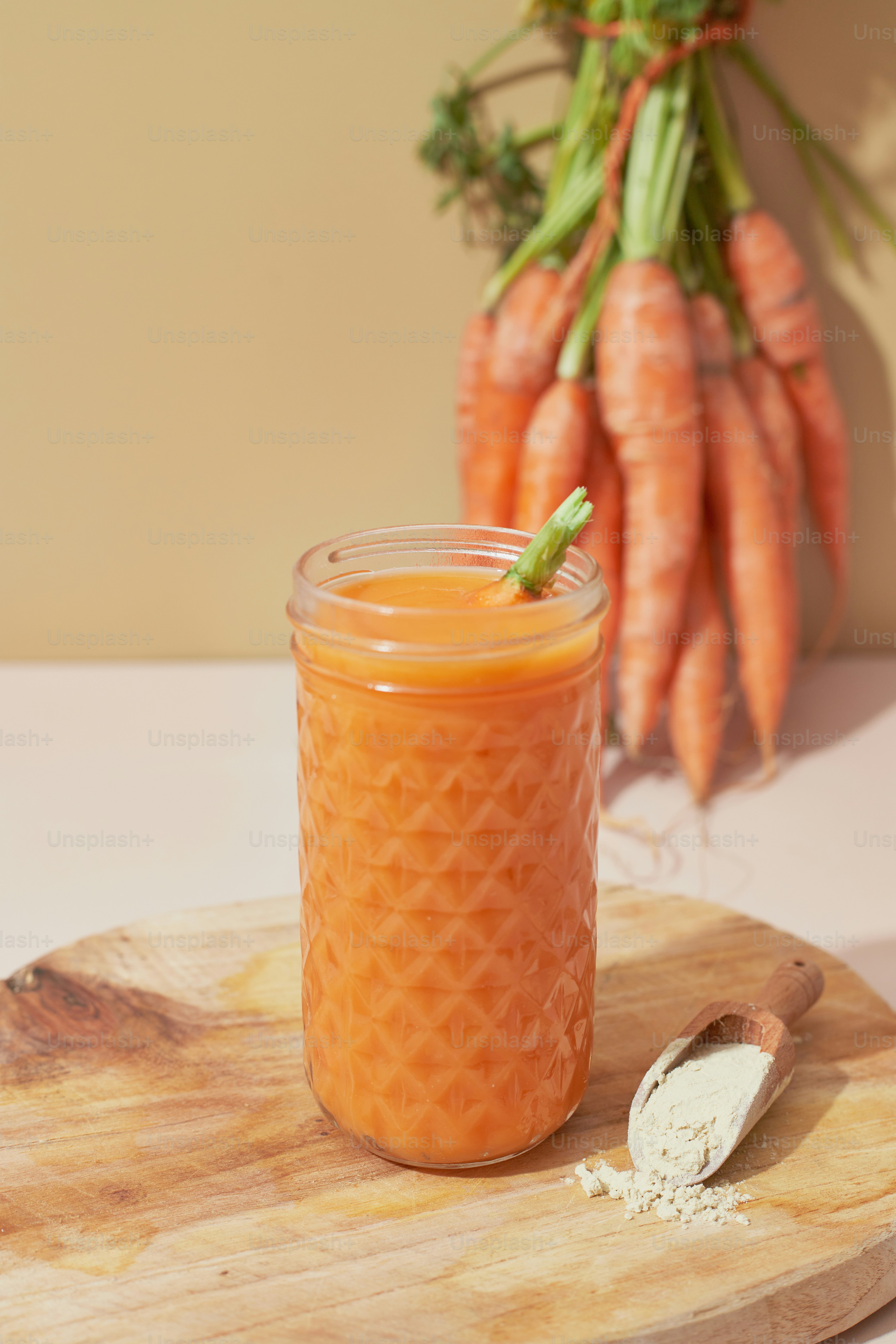 A jar of carrot soup sitting on a cutting board
