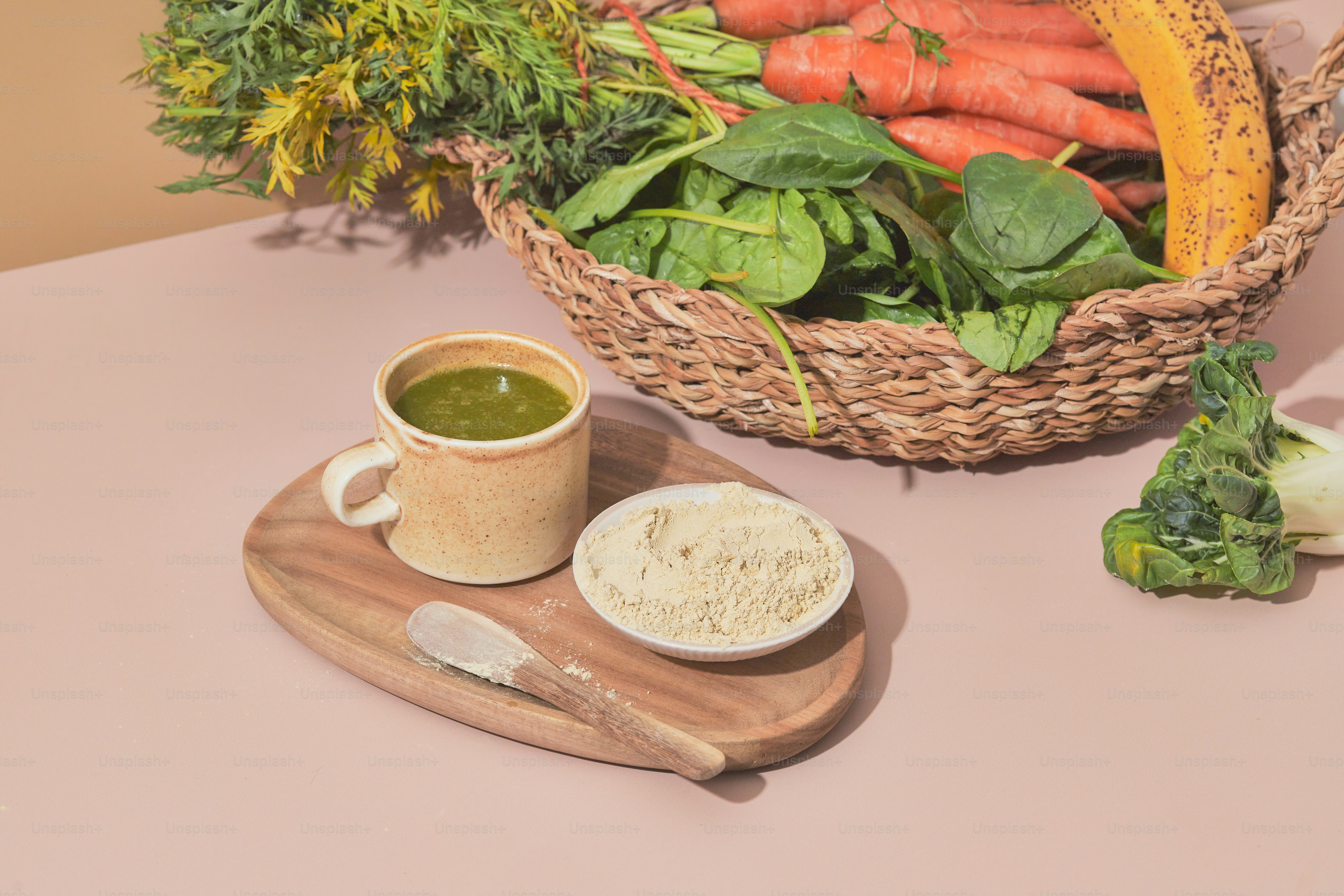 Una cesta de zanahorias y otras verduras sobre una mesa