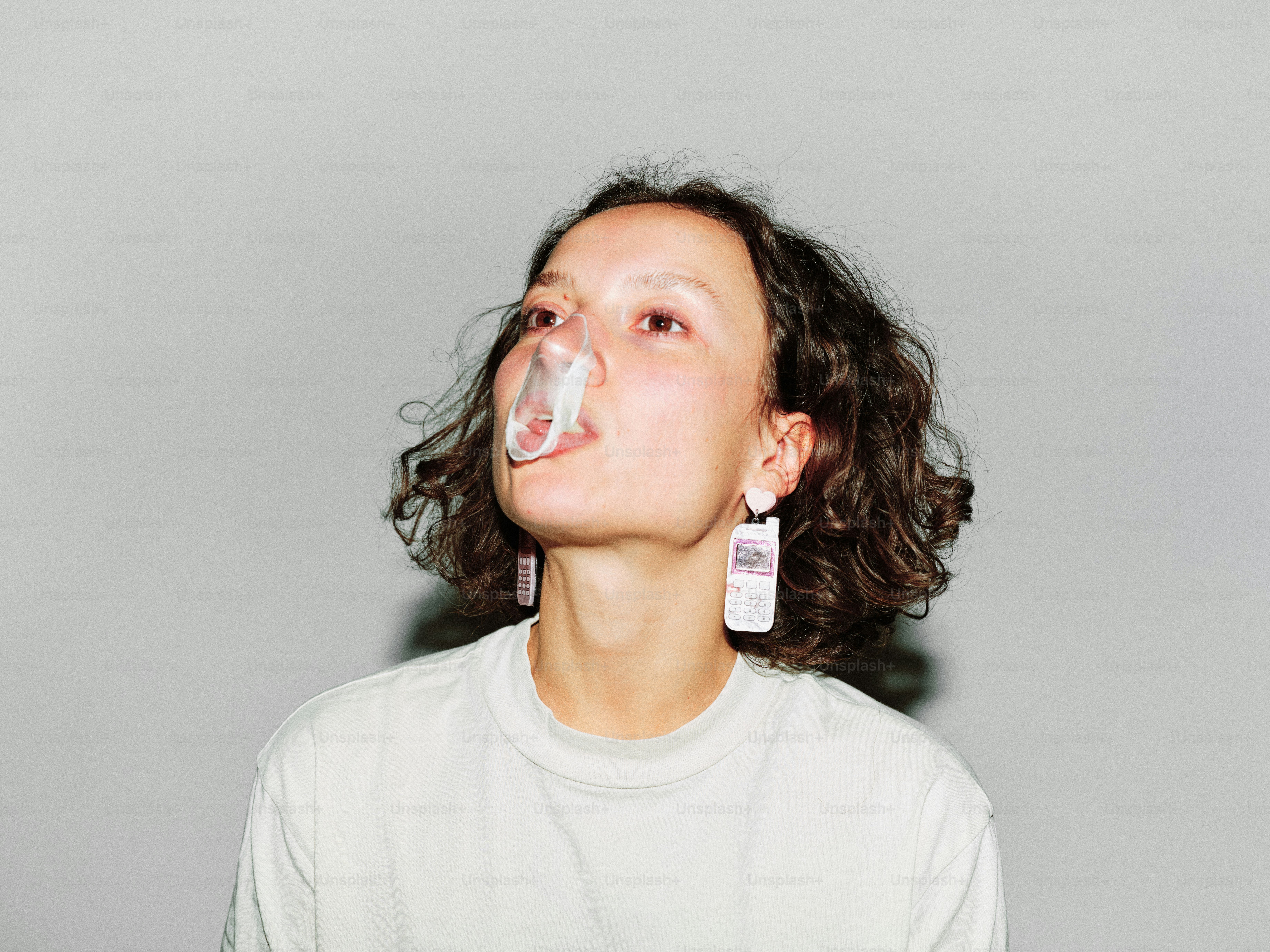 A woman with curly hair blowing bubbles of water