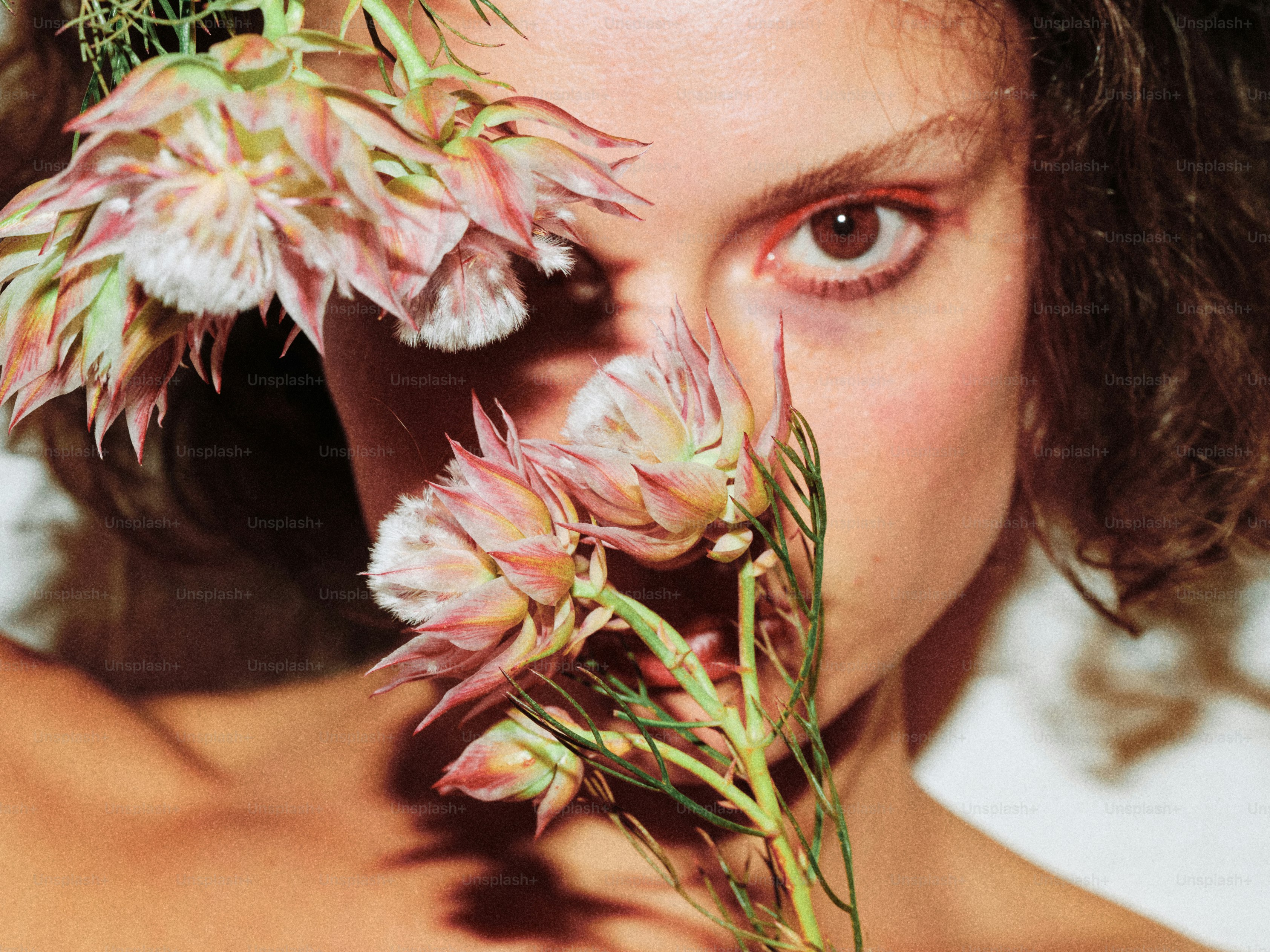 Uma mulher segurando um buquê de flores até o rosto