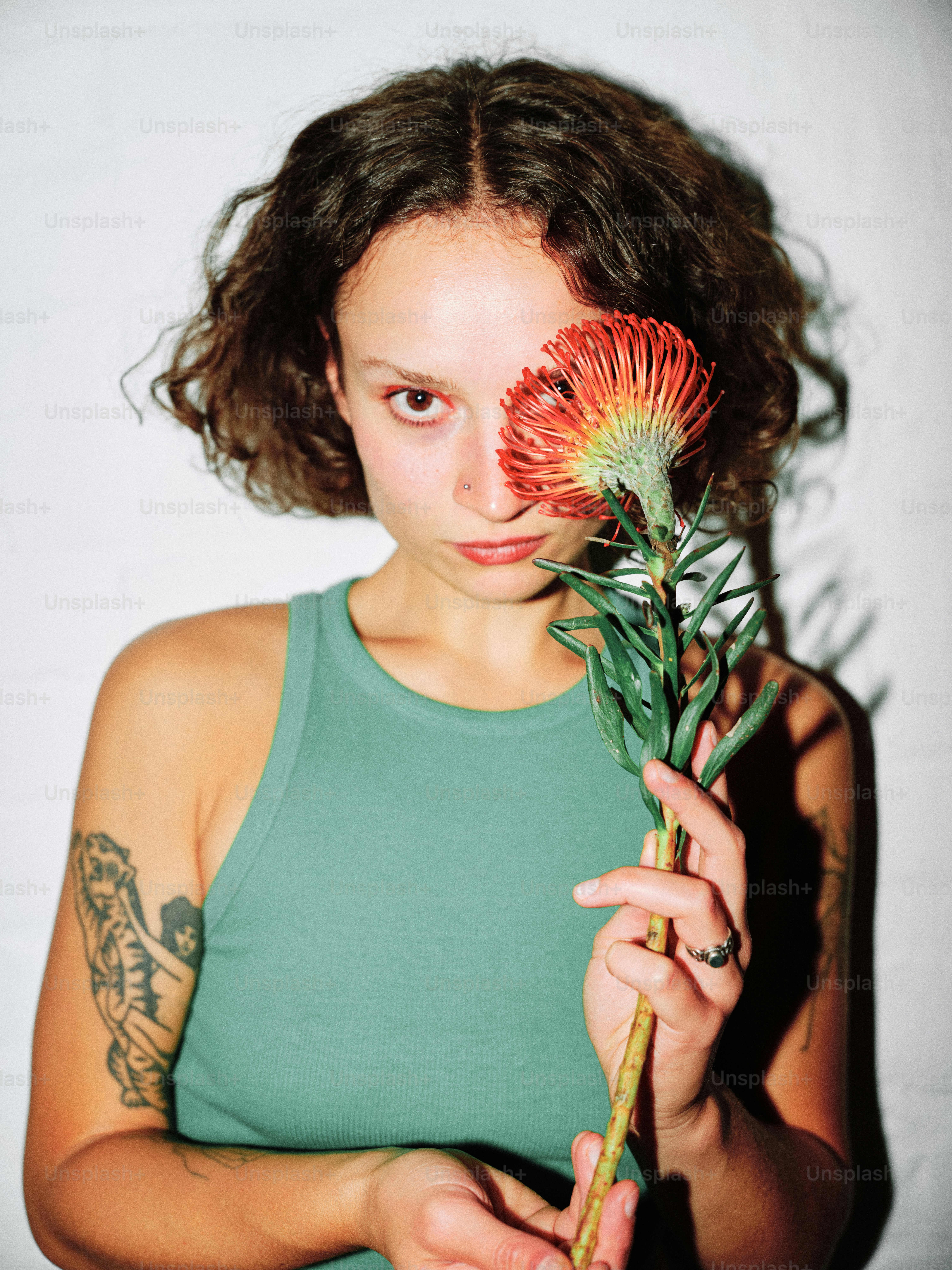 A woman holding a flower in front of her face