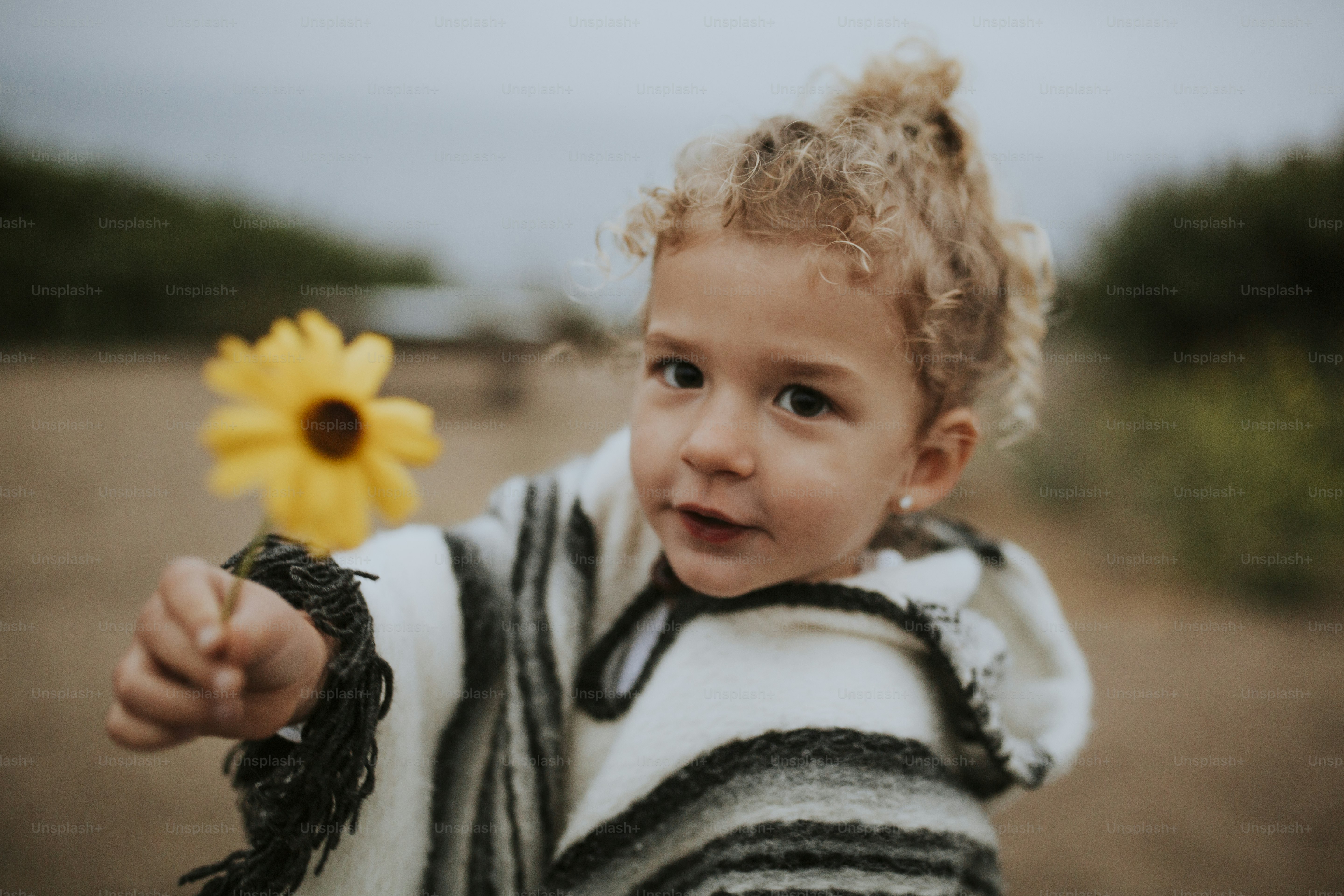Blondes kleines Mädchen mit einer Blume
