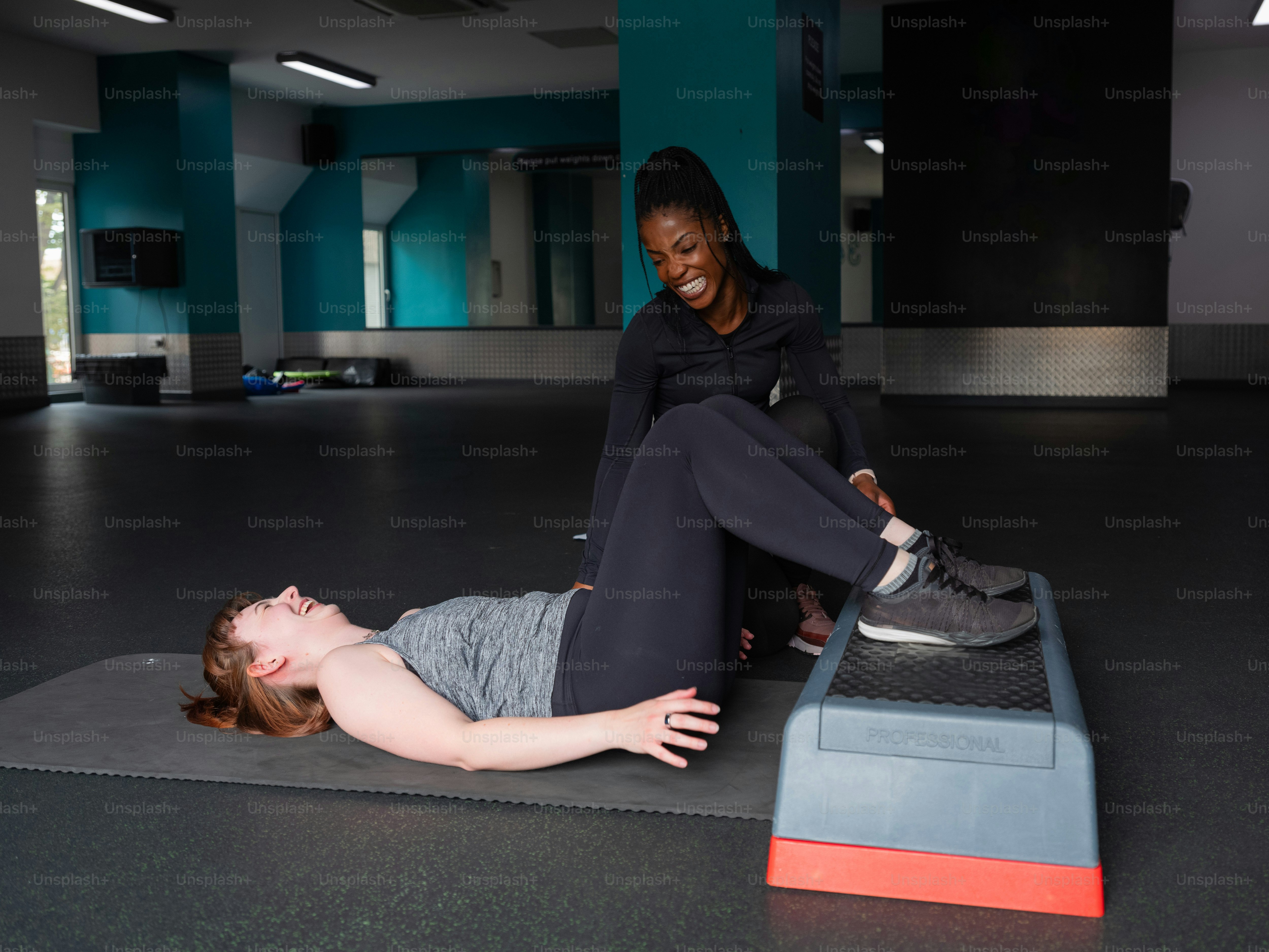 A woman laying on the ground with her feet on a ramp photo – Gym Image ...