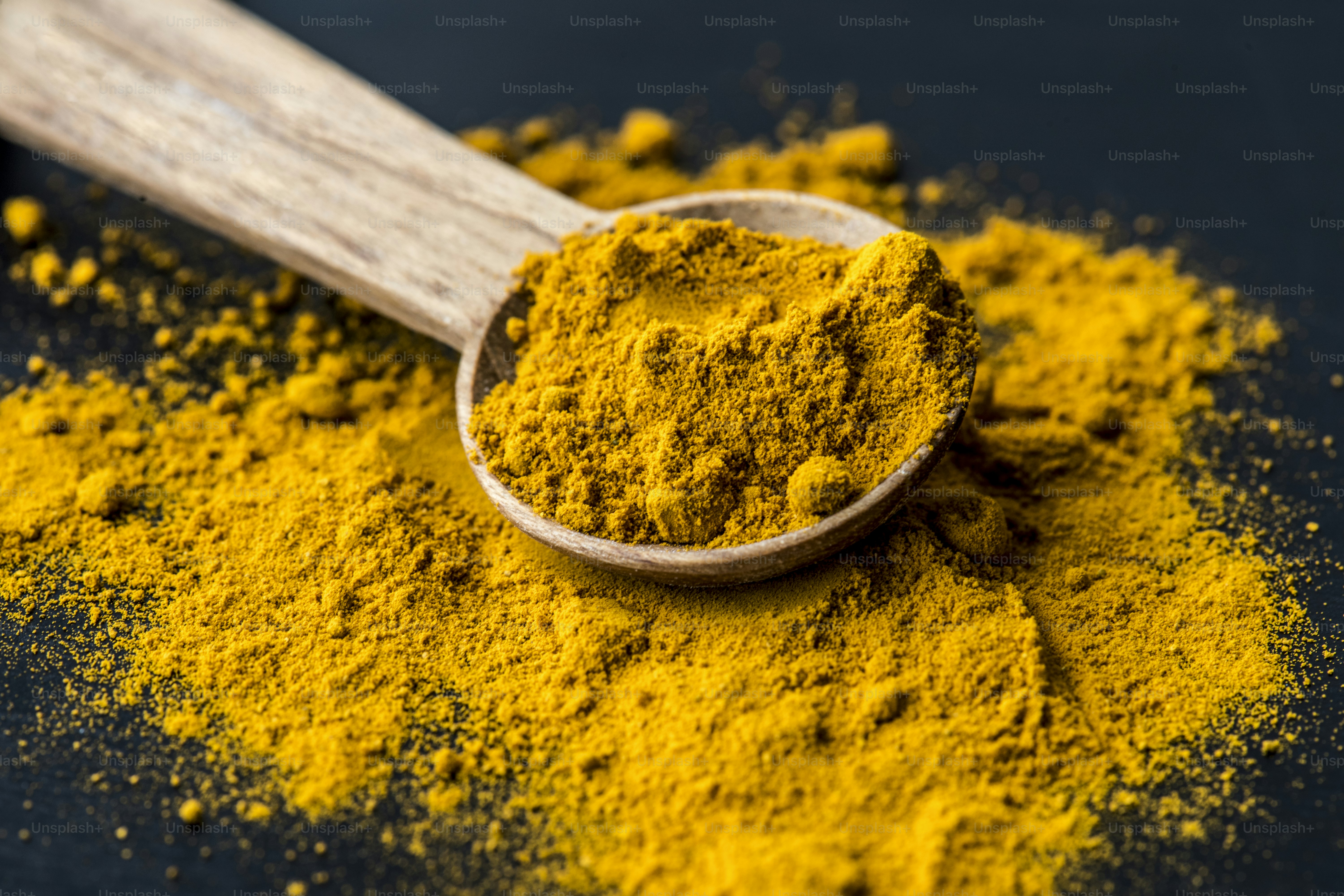 Closeup of tumeric powder spice on a spoon