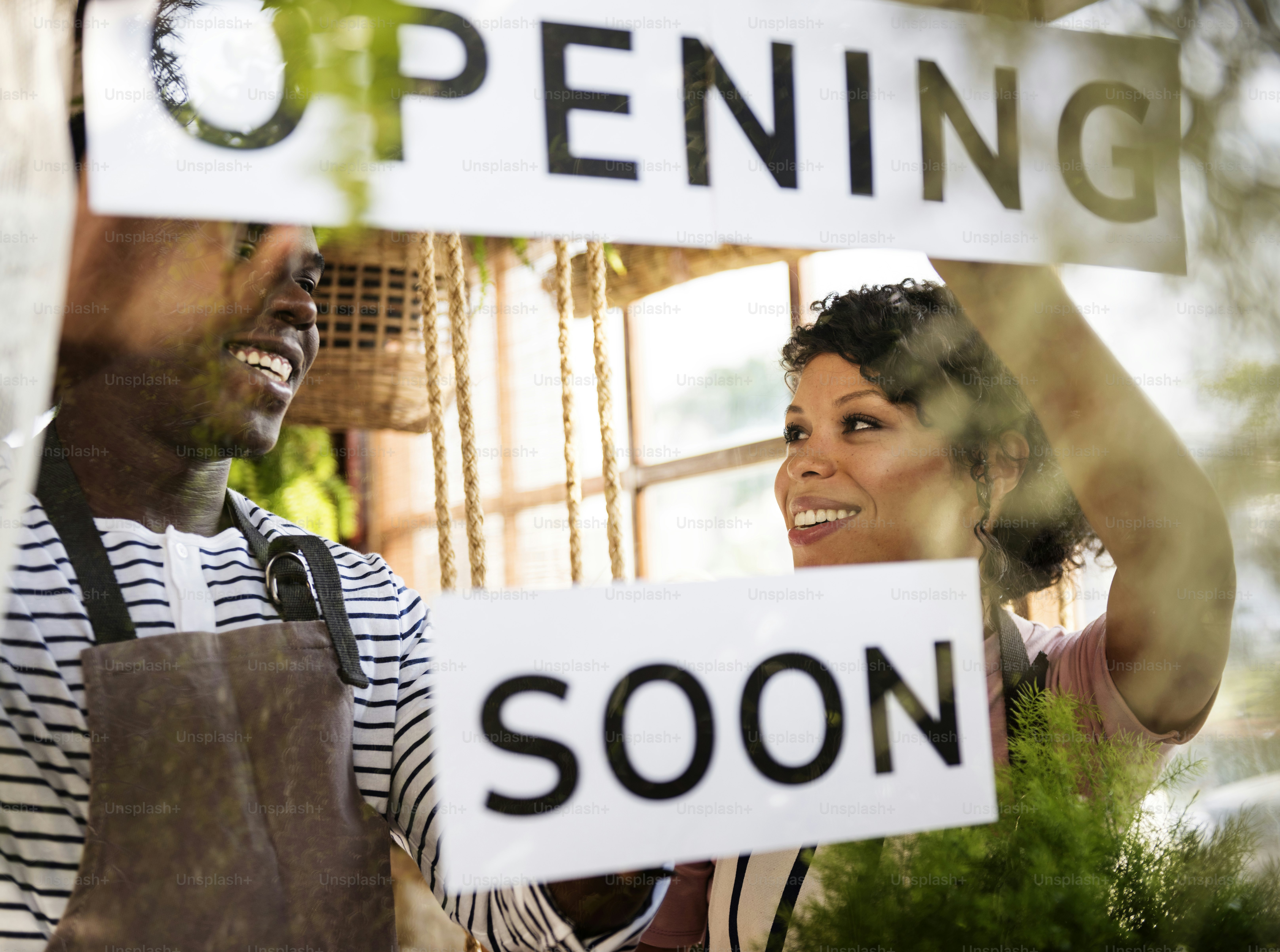 Black Couple Showing Opening Soon Paper Sign