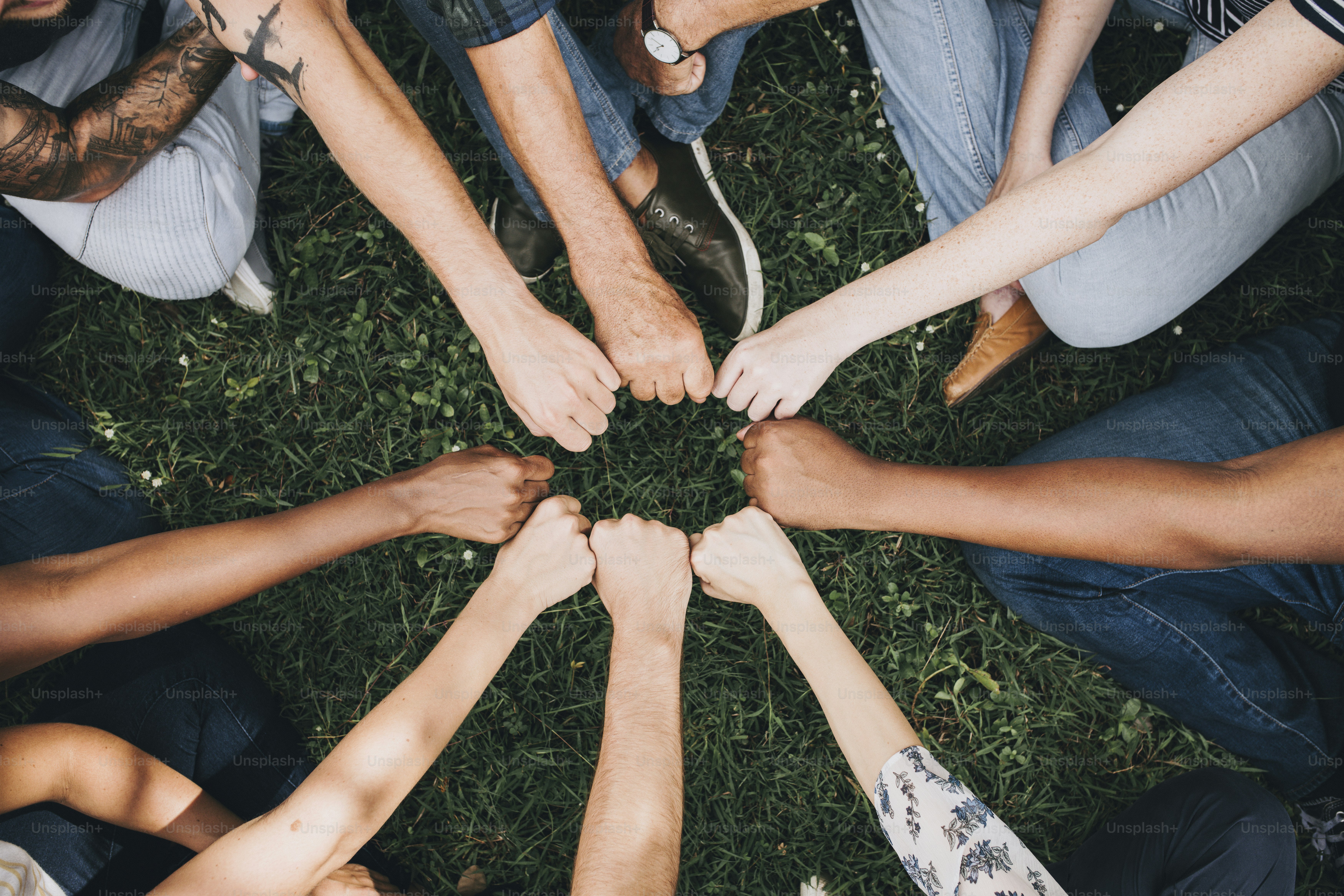Diverse Leute beim Fauststoß im Park