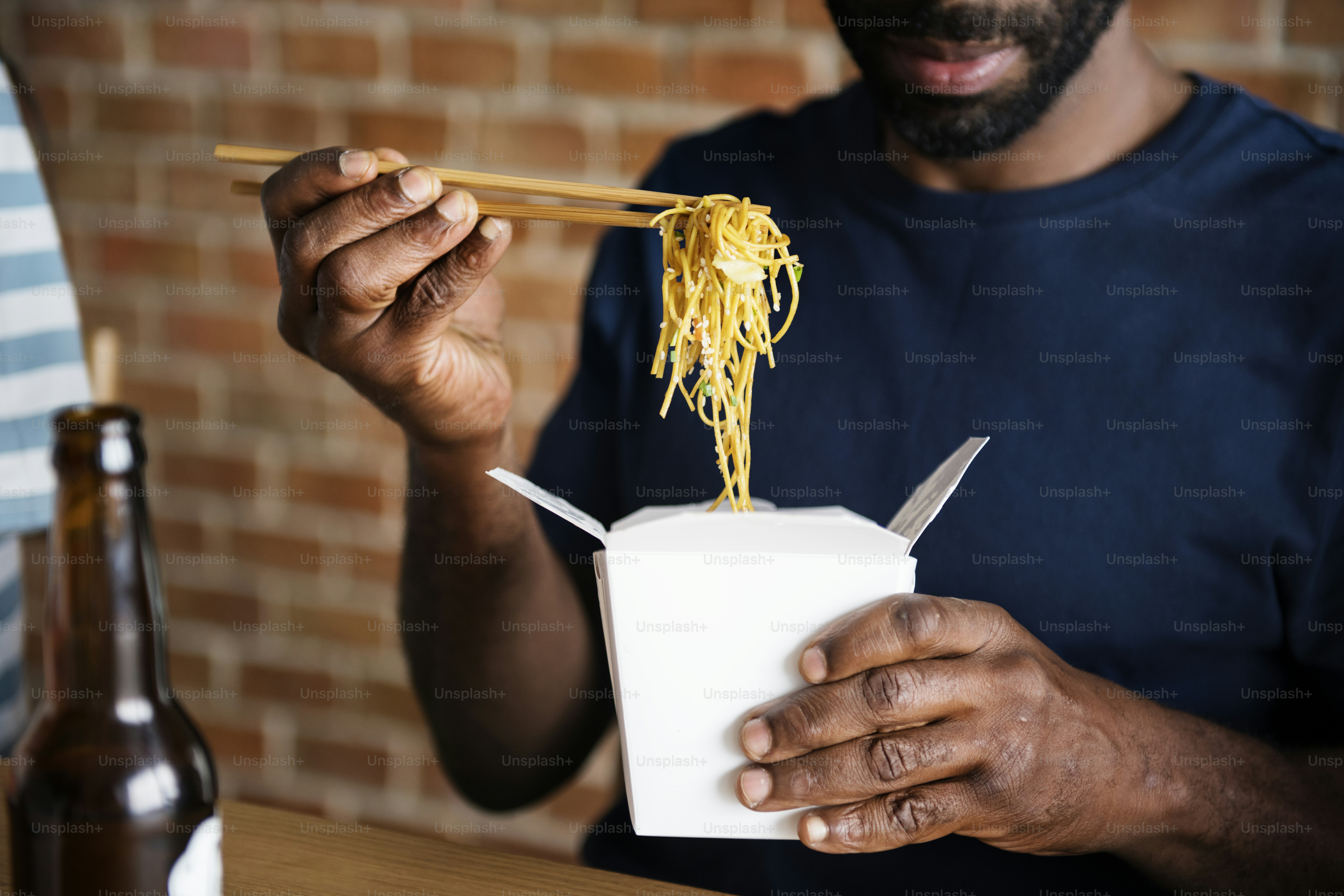 Black man eating Chow mein