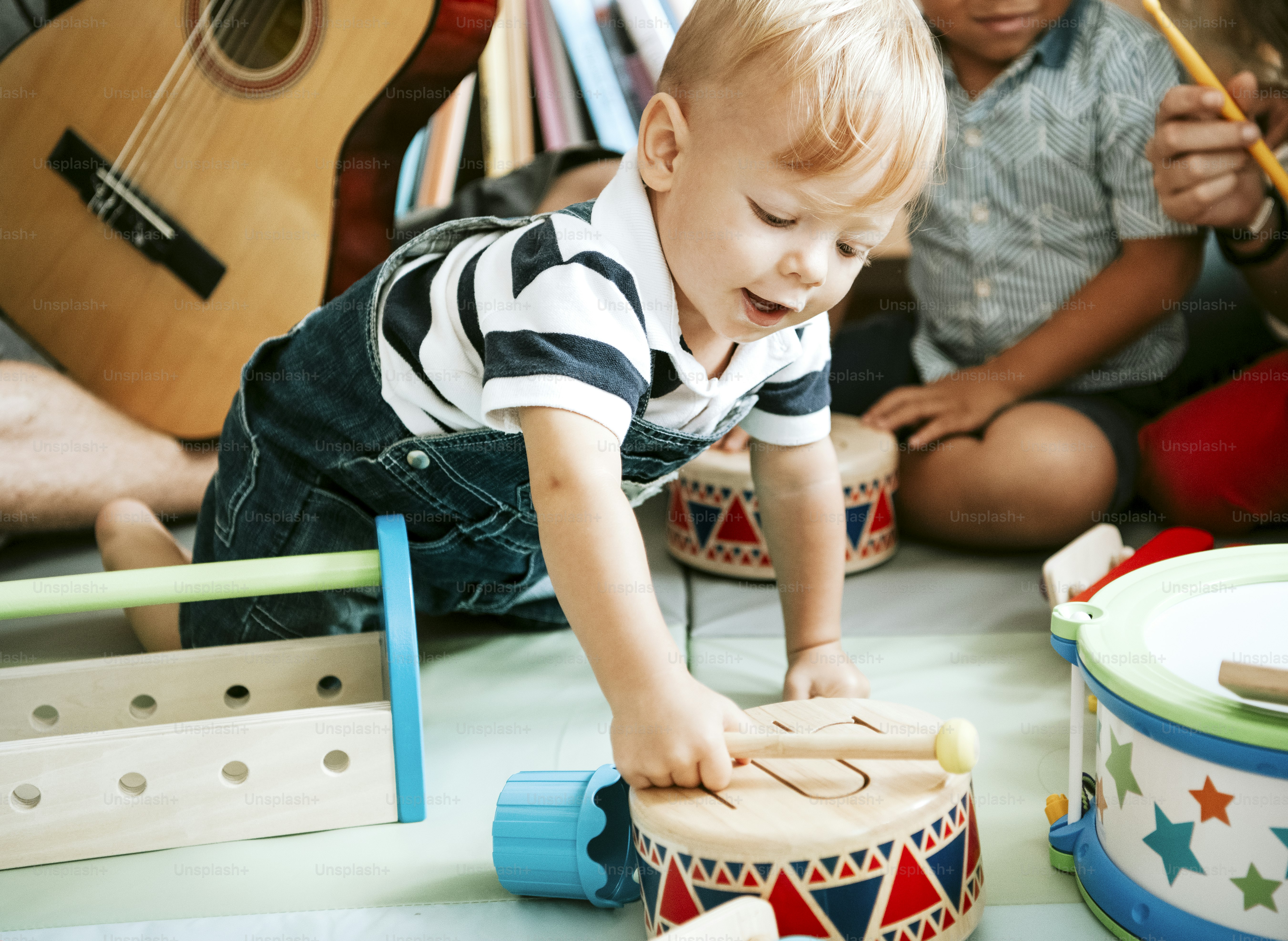 Petit enfant jouant avec une batterie en bois