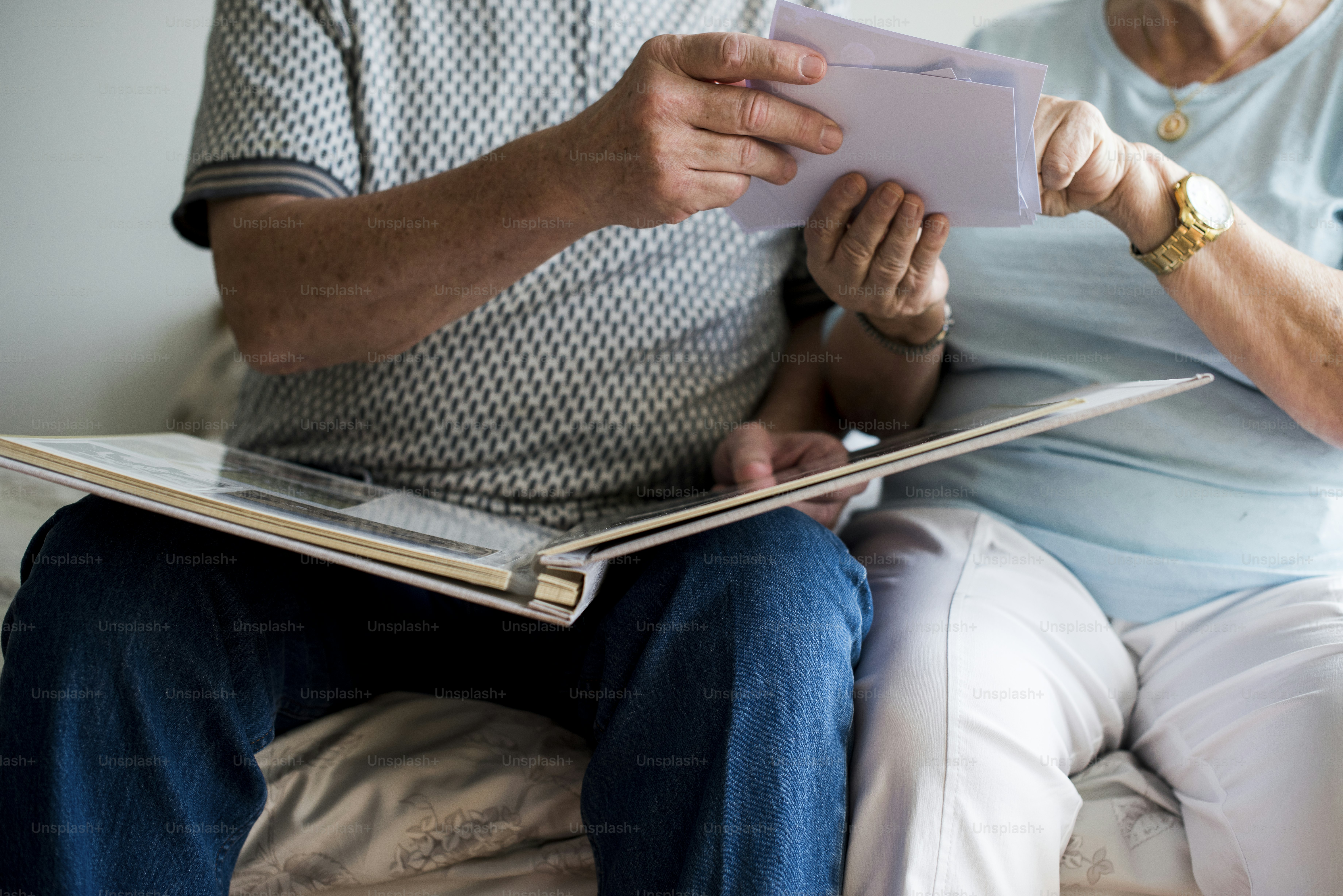 Couple de personnes âgées regardant un album photo de famille