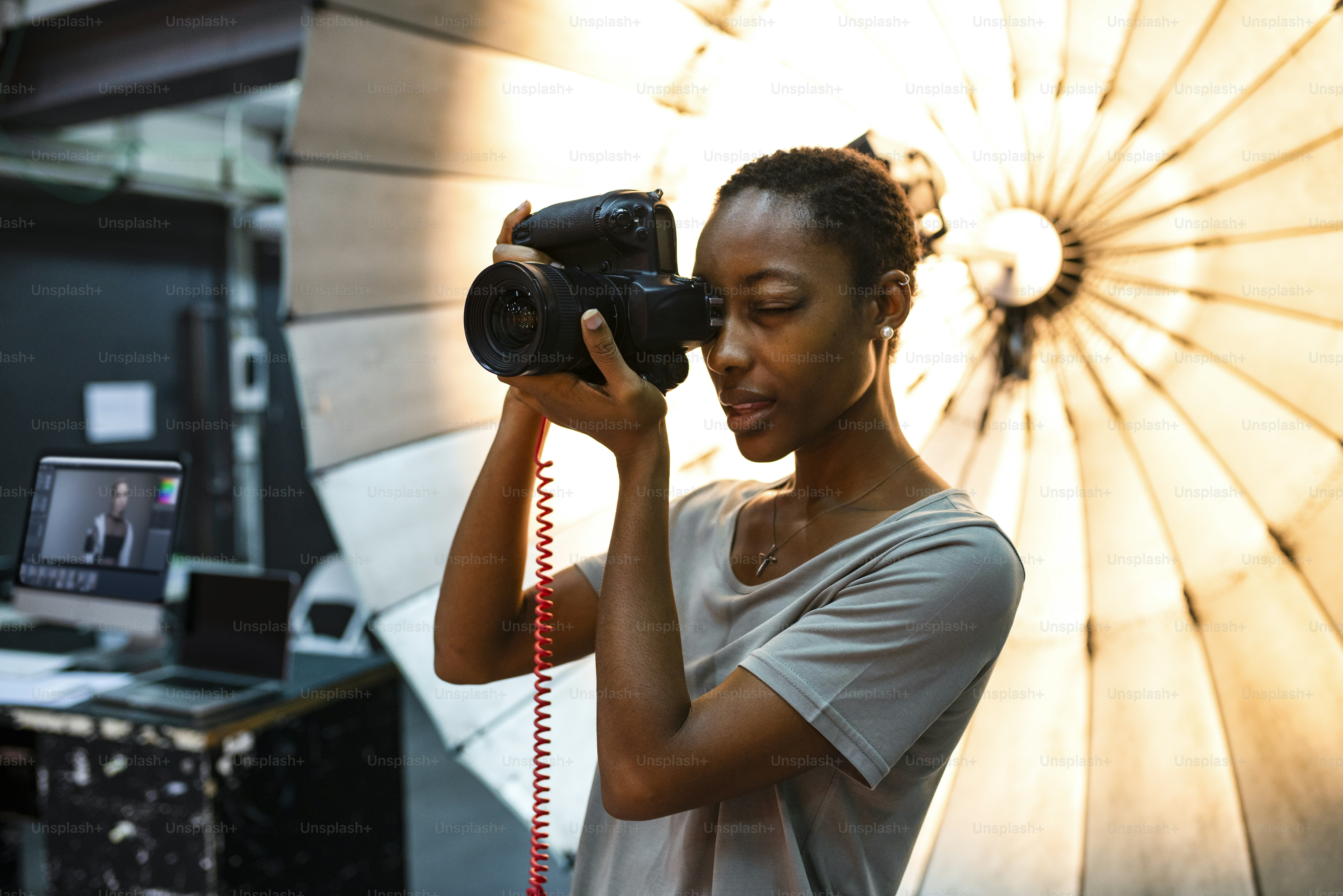 Young photographer standing in front of a reflective umbrella