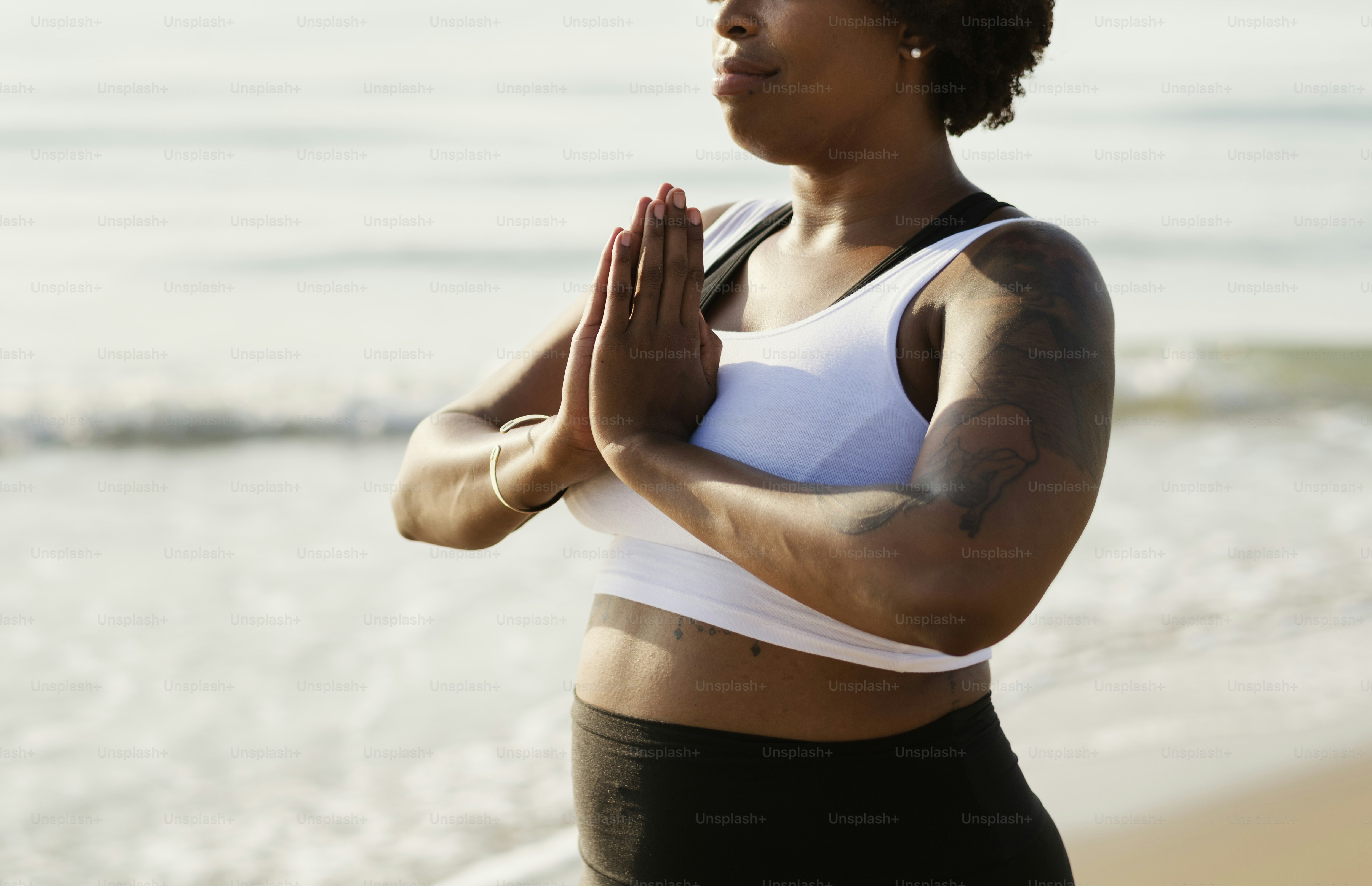 African American woman practicing yoga at the beach
