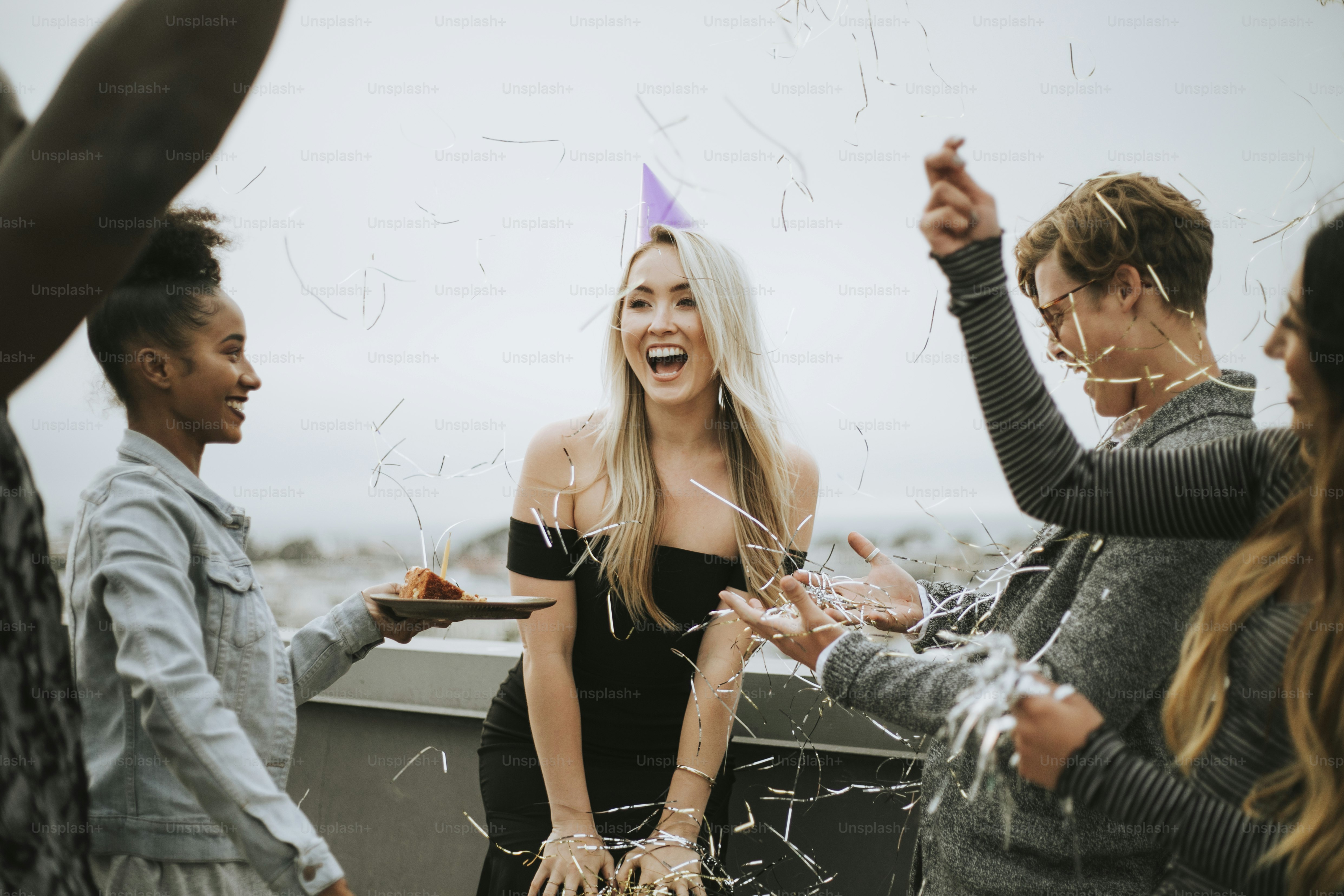 Amici allegri che festeggiano una festa di compleanno su un tetto