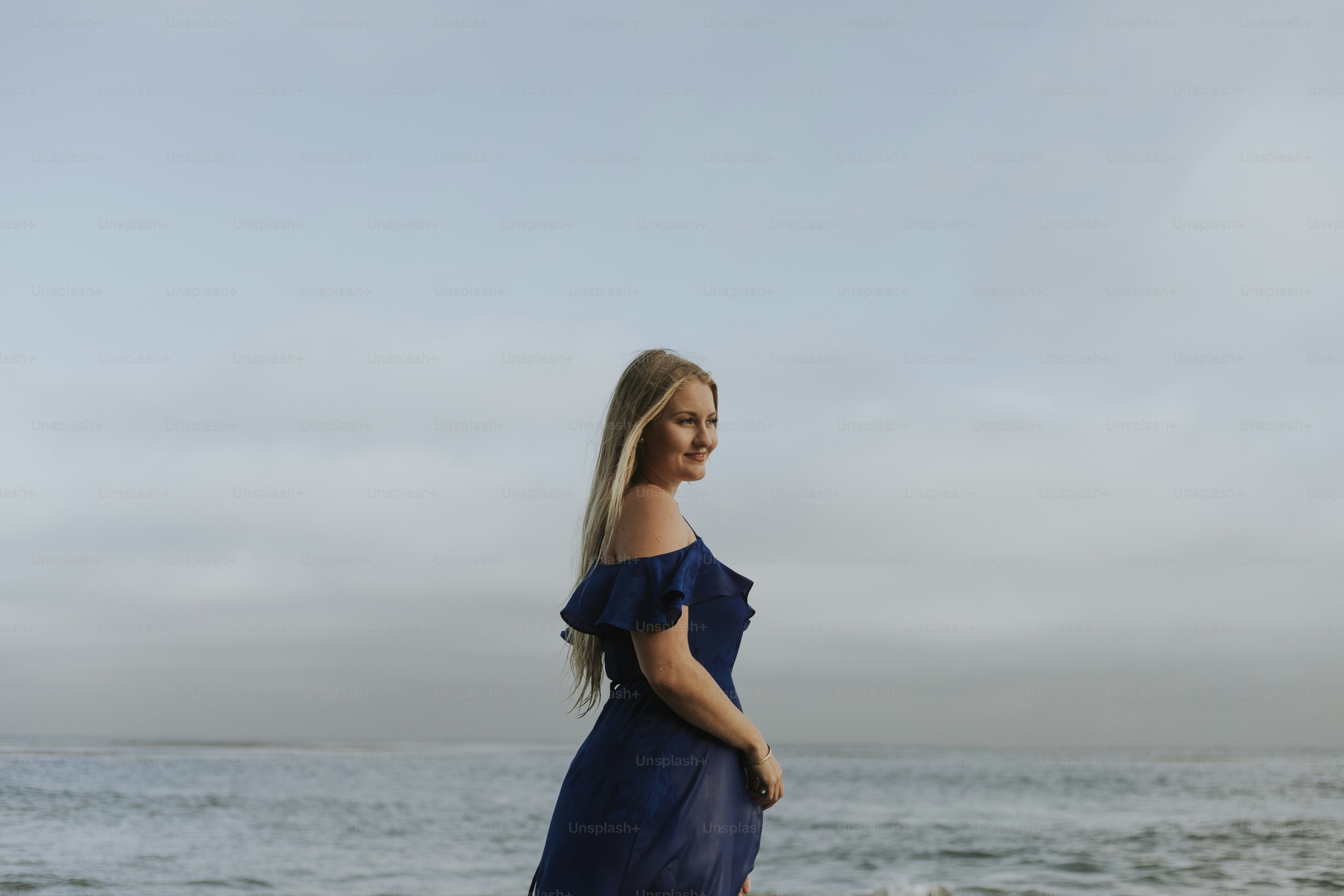 Cheerful woman in a blue dress smiling staying by the sea photo – Beach ...