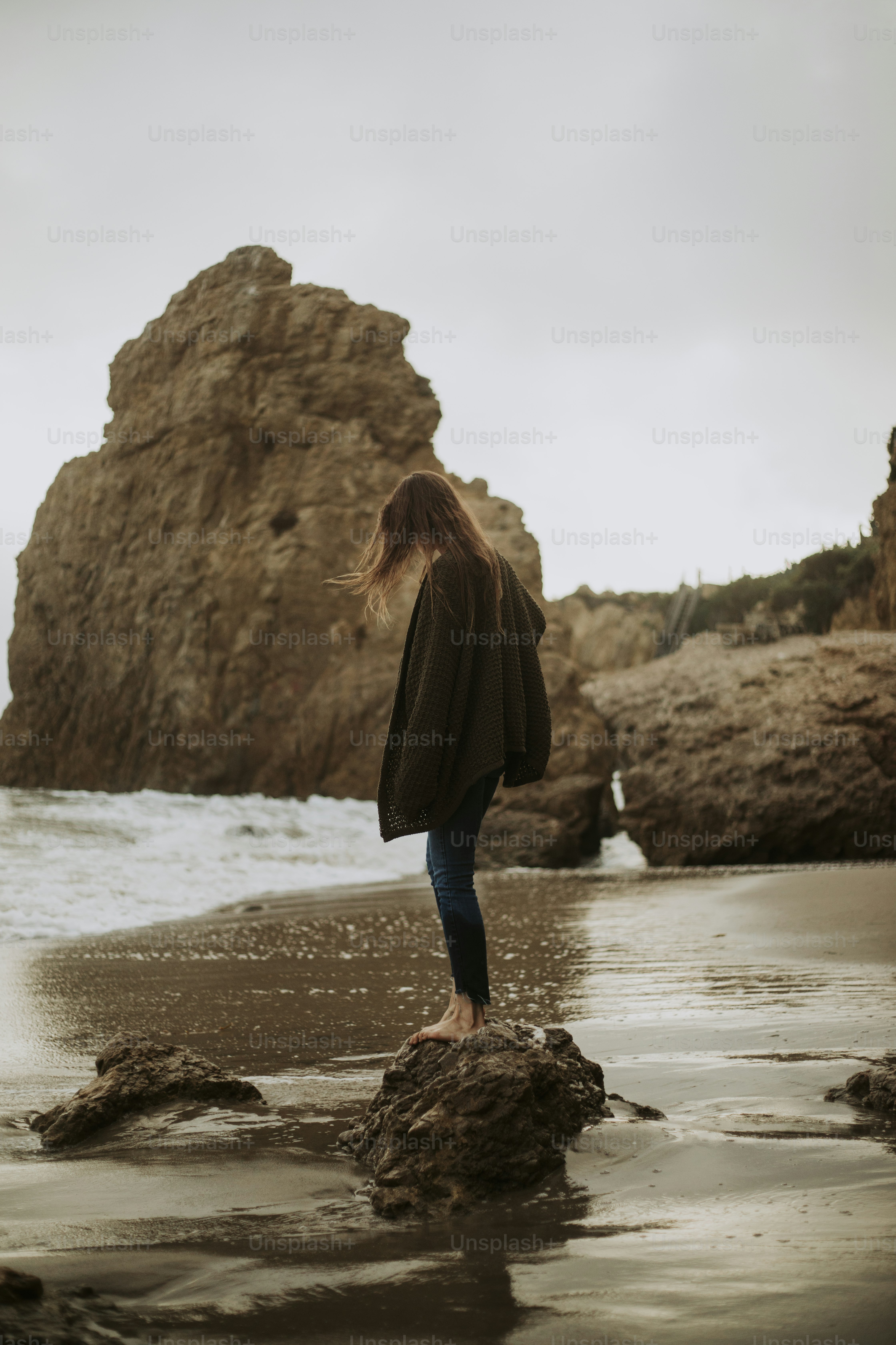 Woman standing on a rock at the beach