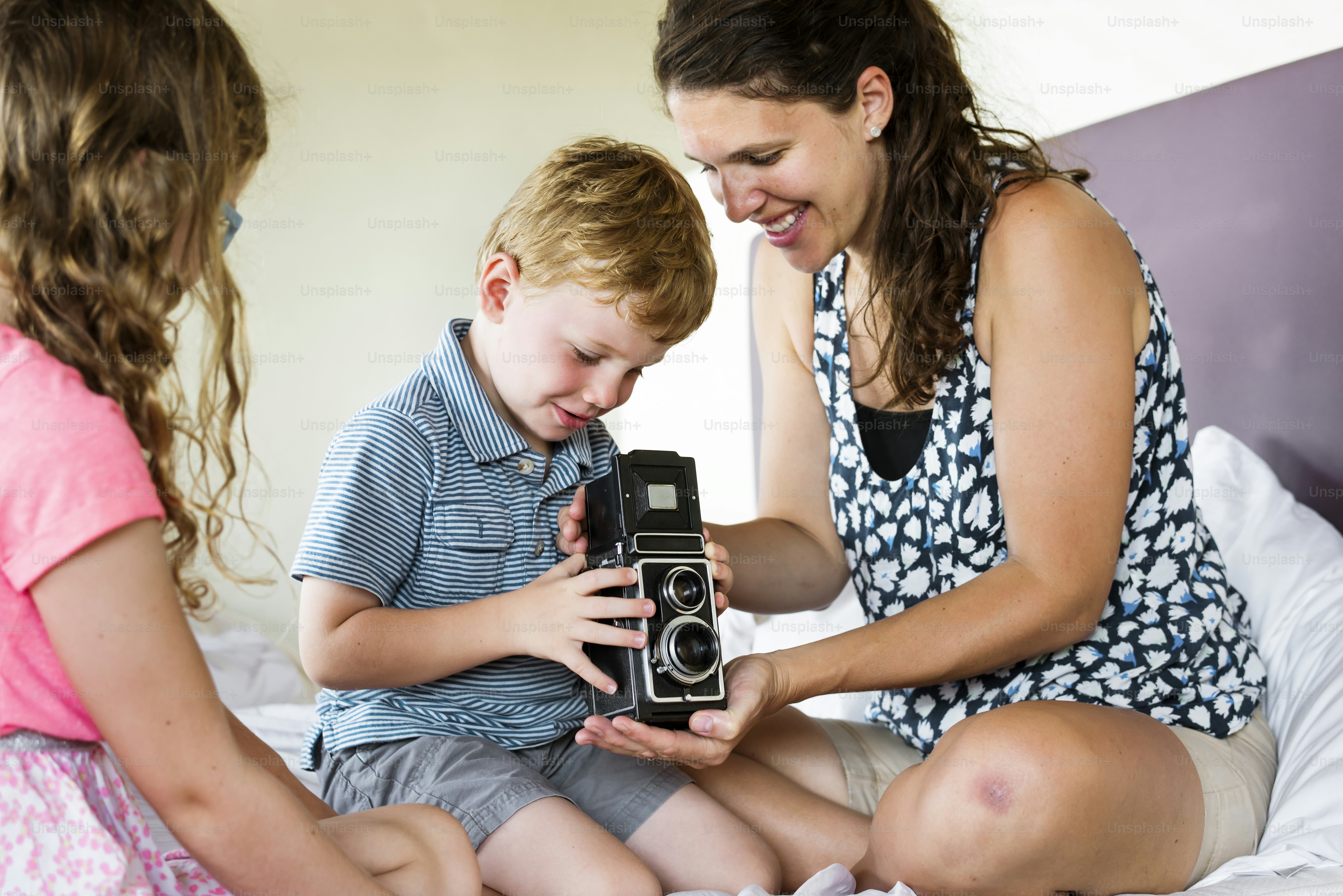 Mother teaching her son to use analog camera
