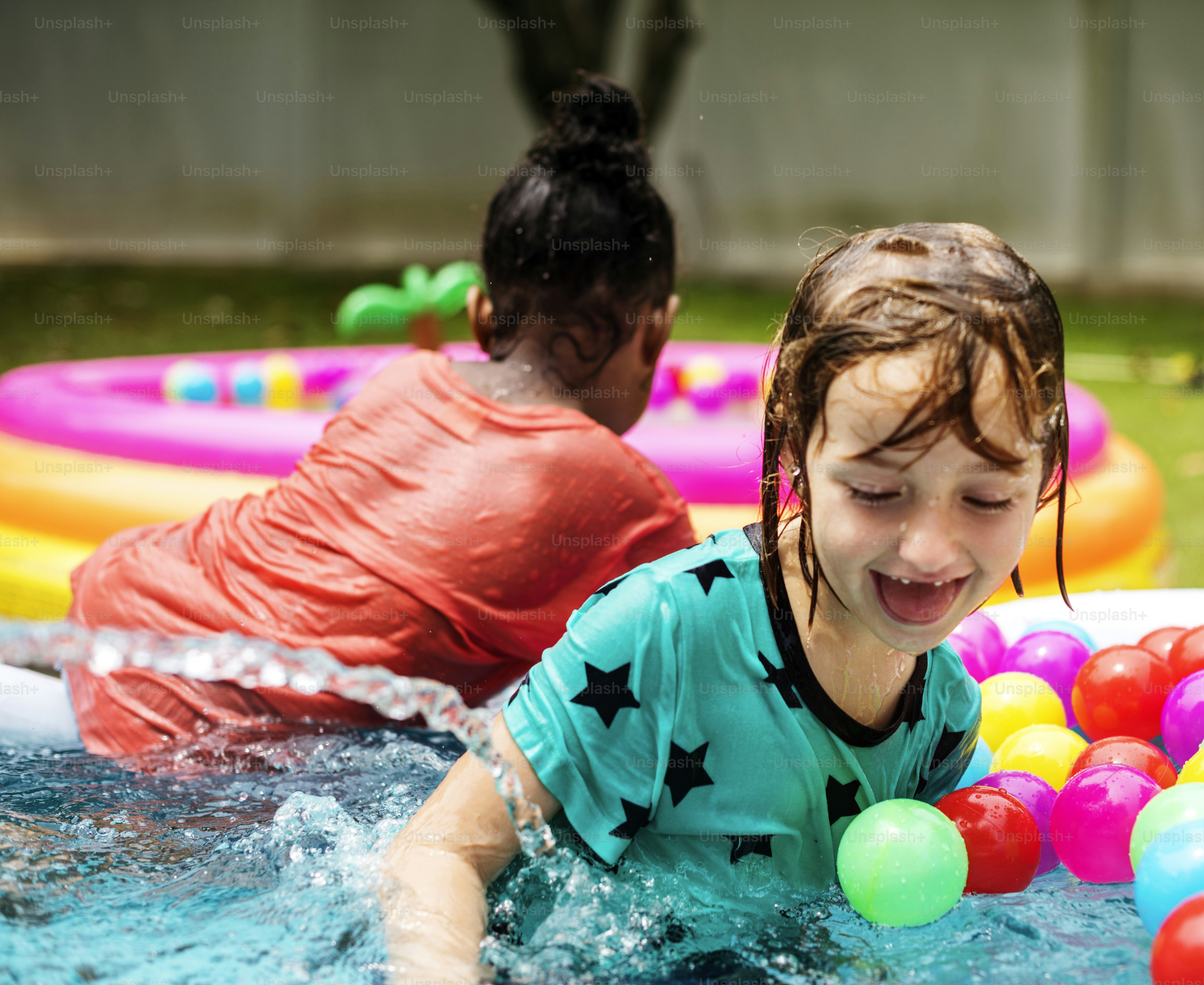 Niño jugando en una piscina de goma