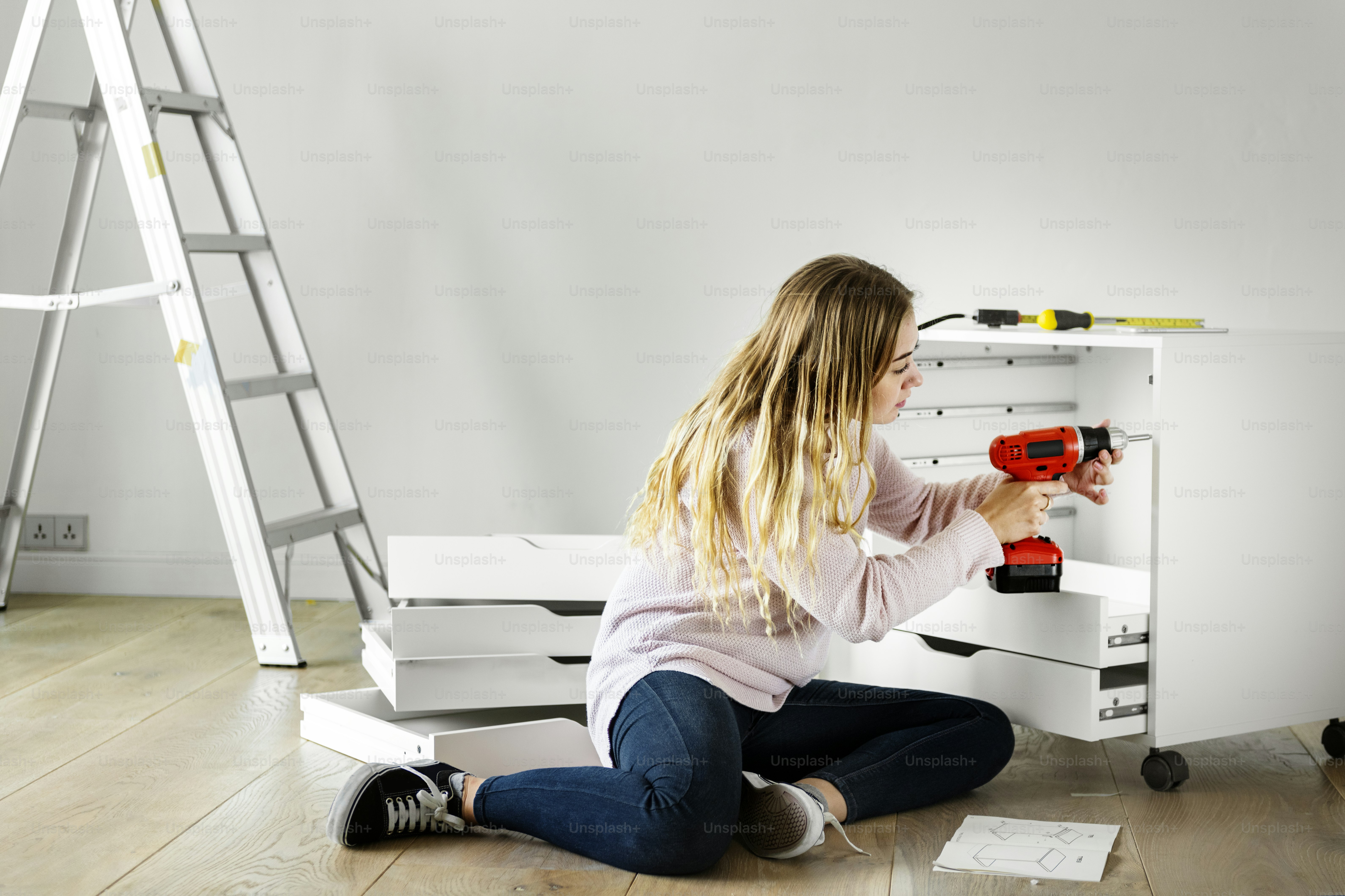 Donna che utilizza l'armadio di installazione del trapano elettronico