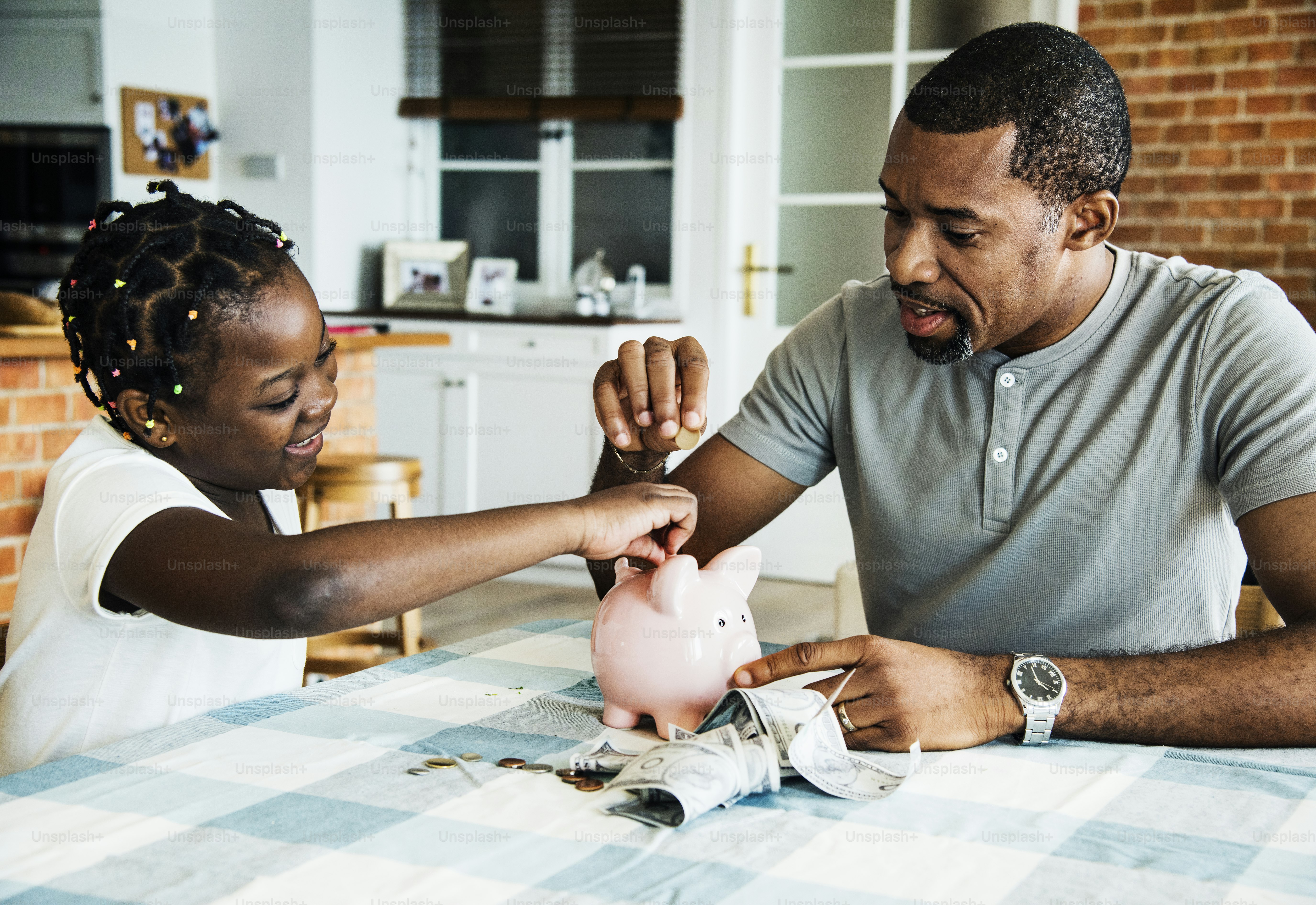 Dad and daughter saving money to piggy bank