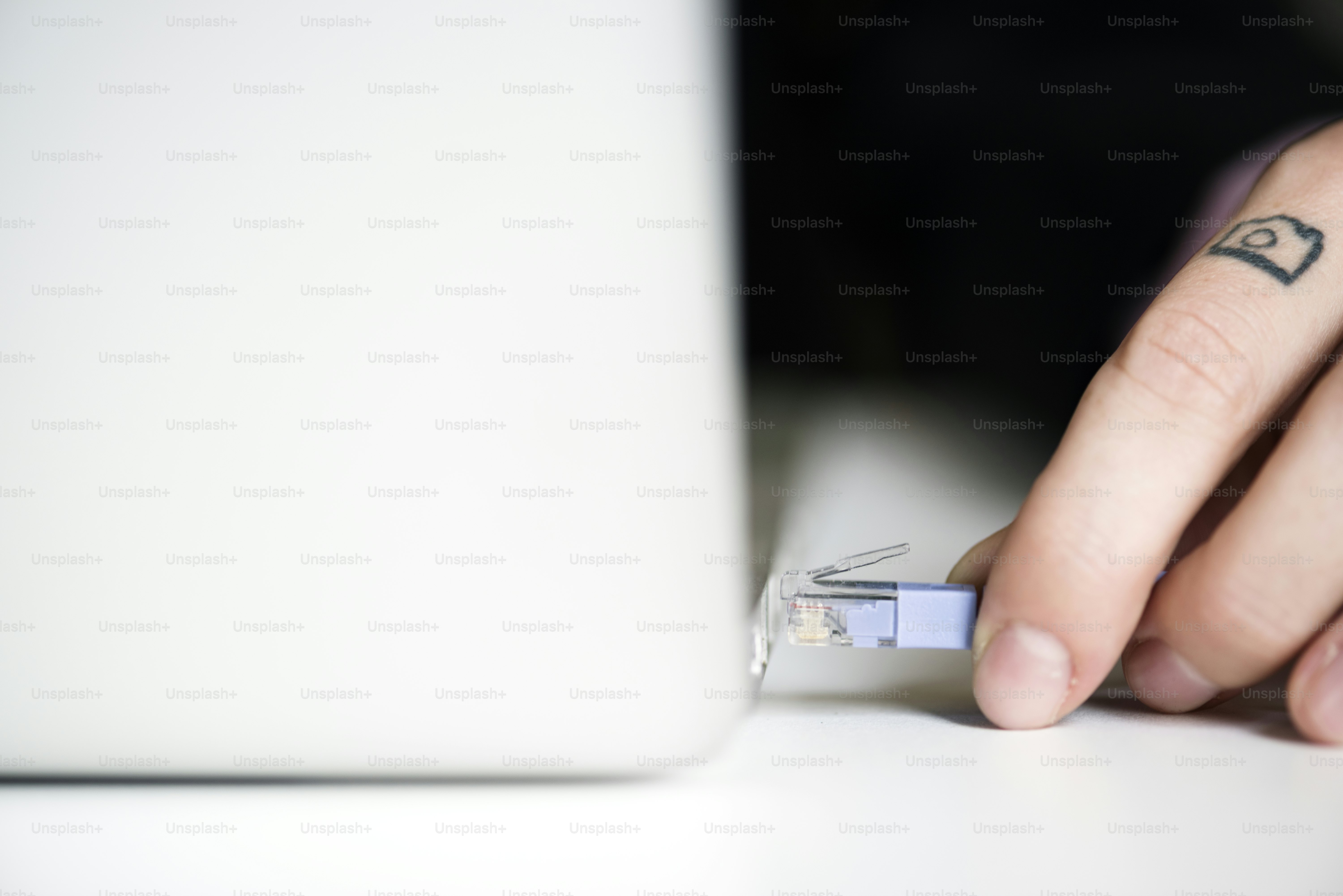 LAN-Kabel mit der Hand an den Laptop anschließen