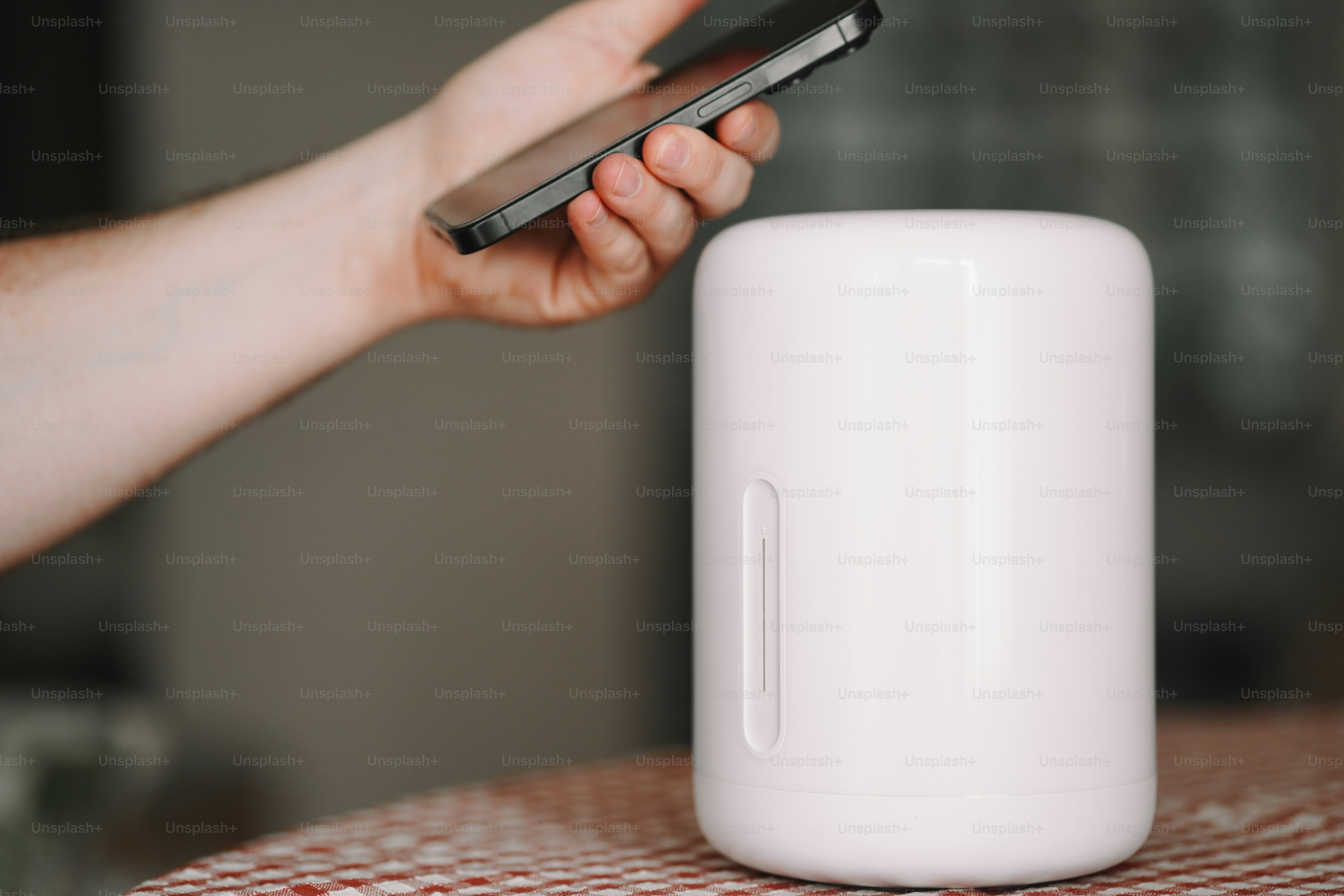 A person holding a cell phone next to a white object