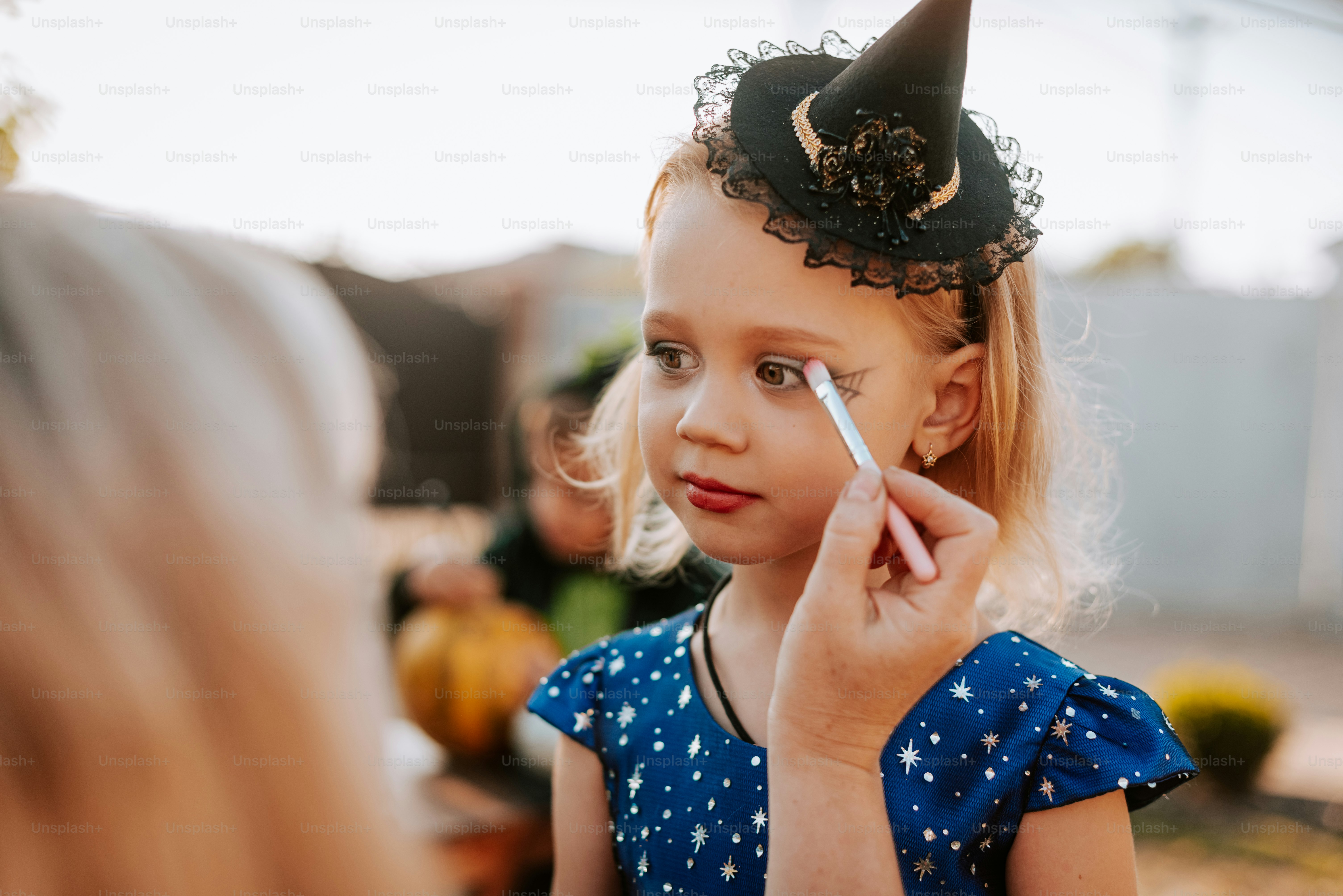 A little girl is putting on a party hat
