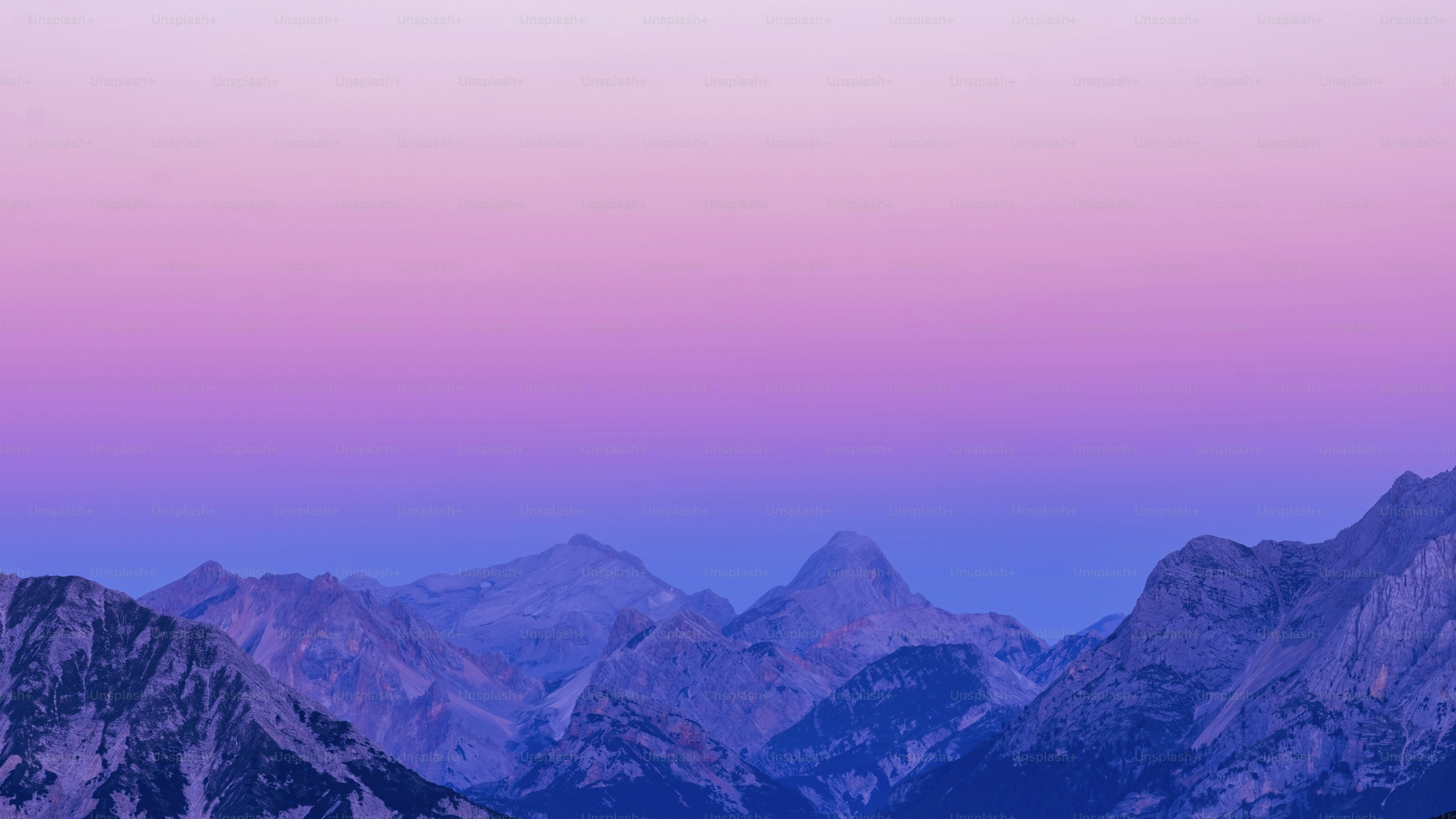 Un avión sobrevolando una cadena montañosa al anochecer