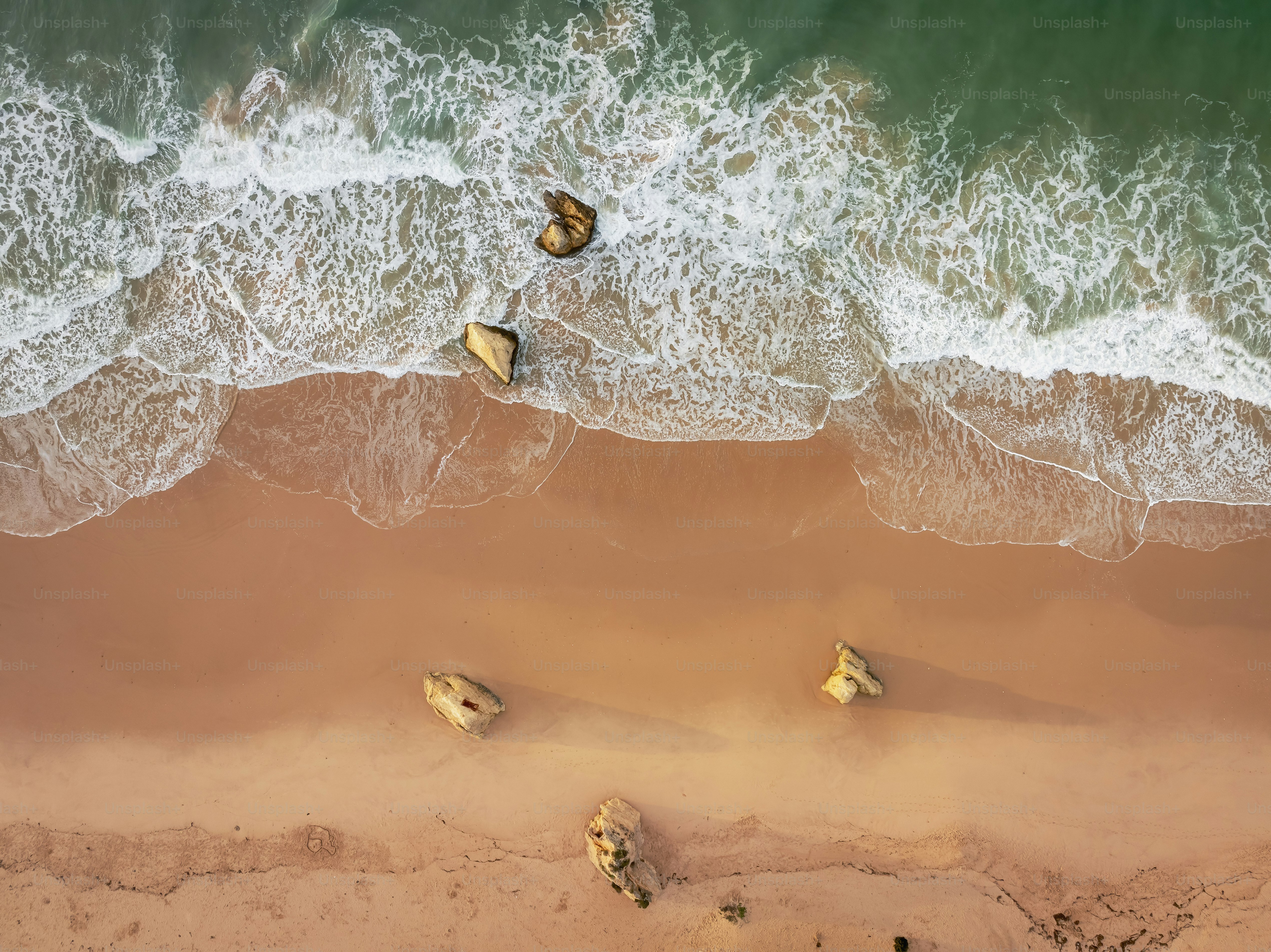 An aerial view of a sandy beach and ocean