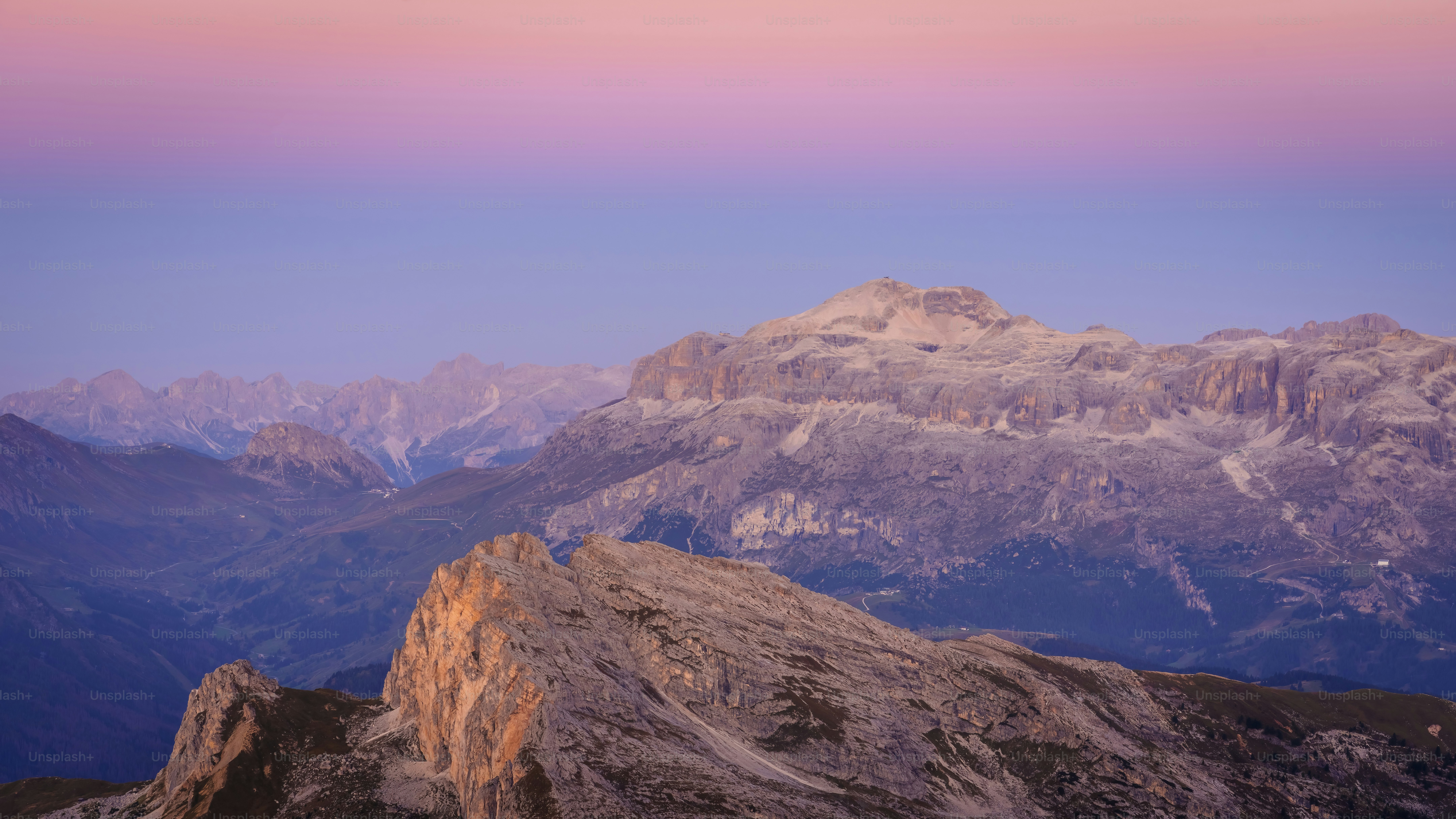 A view of a mountain range with a pink sky