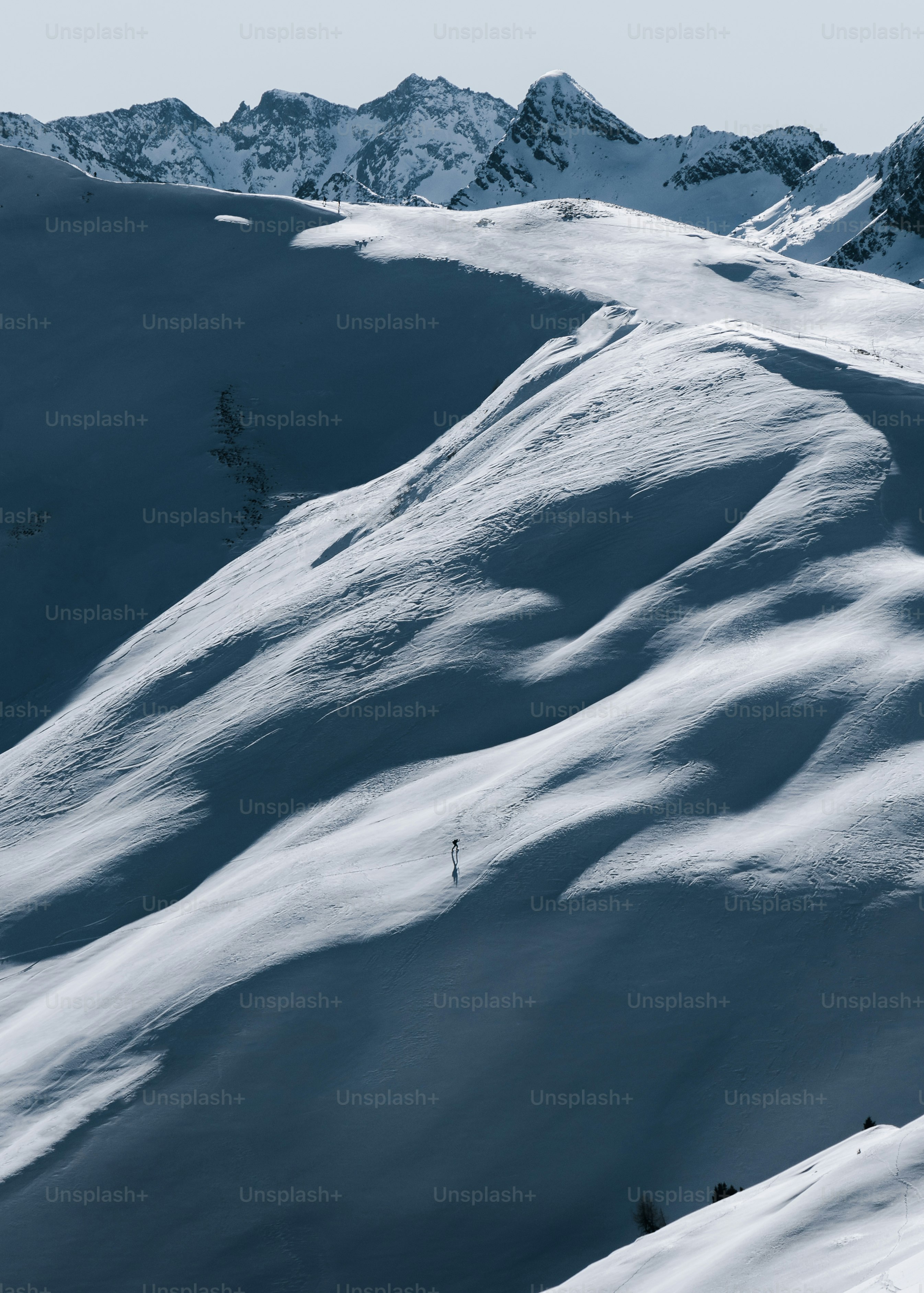 A man riding a snowboard down the side of a snow covered slope