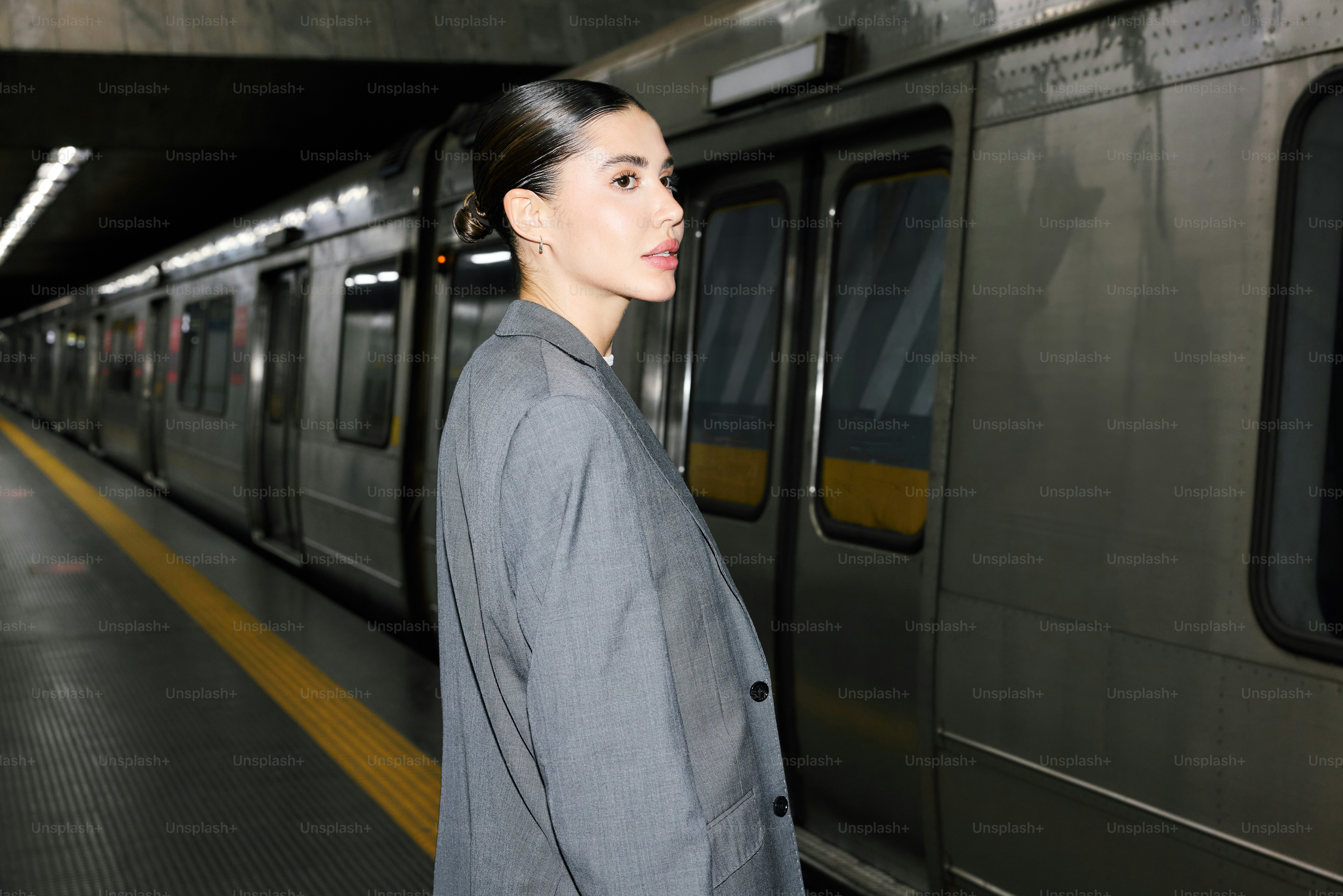 Una mujer de pie frente a un tren subterráneo foto – Imagen de Retrato ...