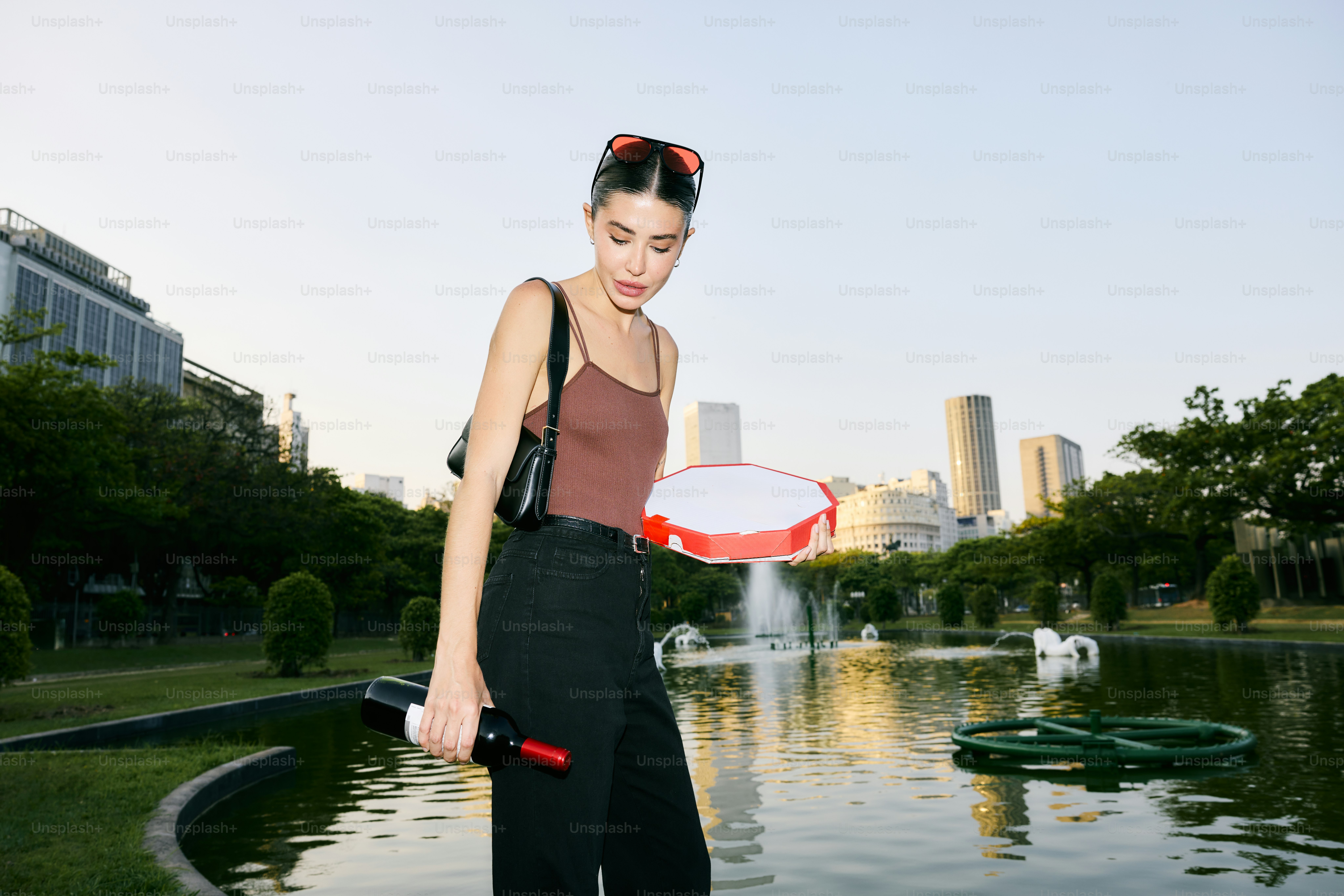 A woman standing in front of a pond holding a frisbee