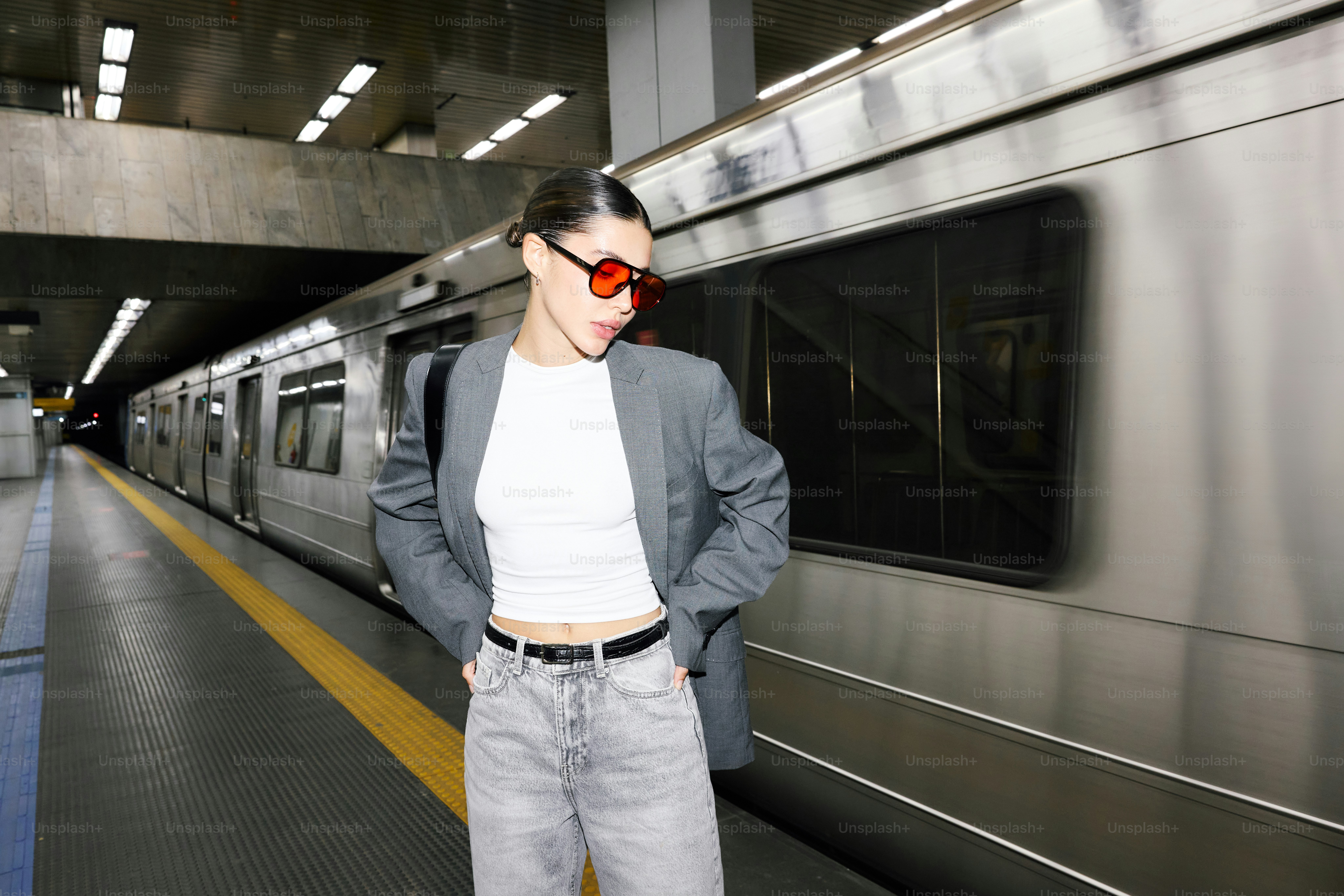 A woman standing in front of a subway train