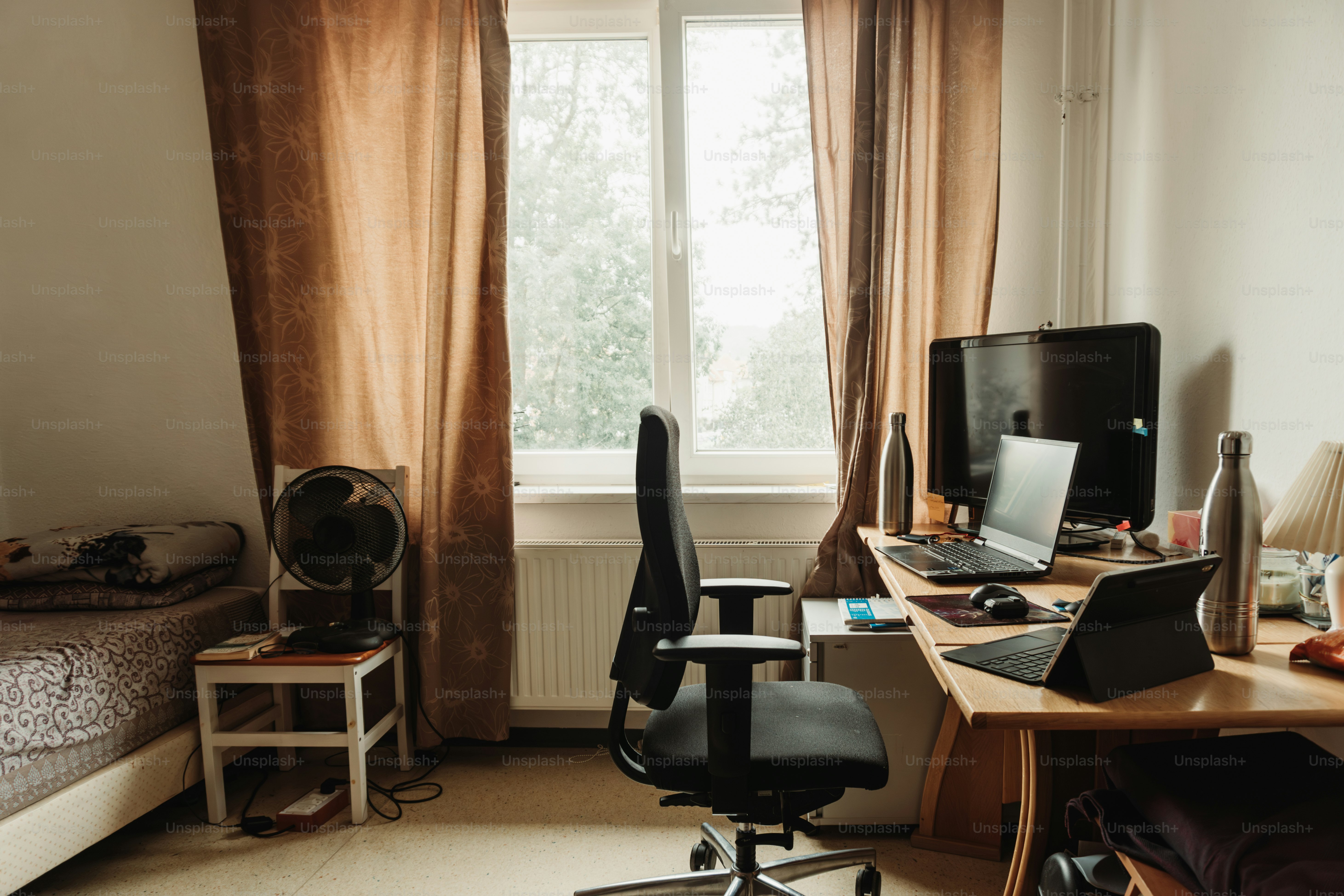 A bedroom with a bed, desk, and computer