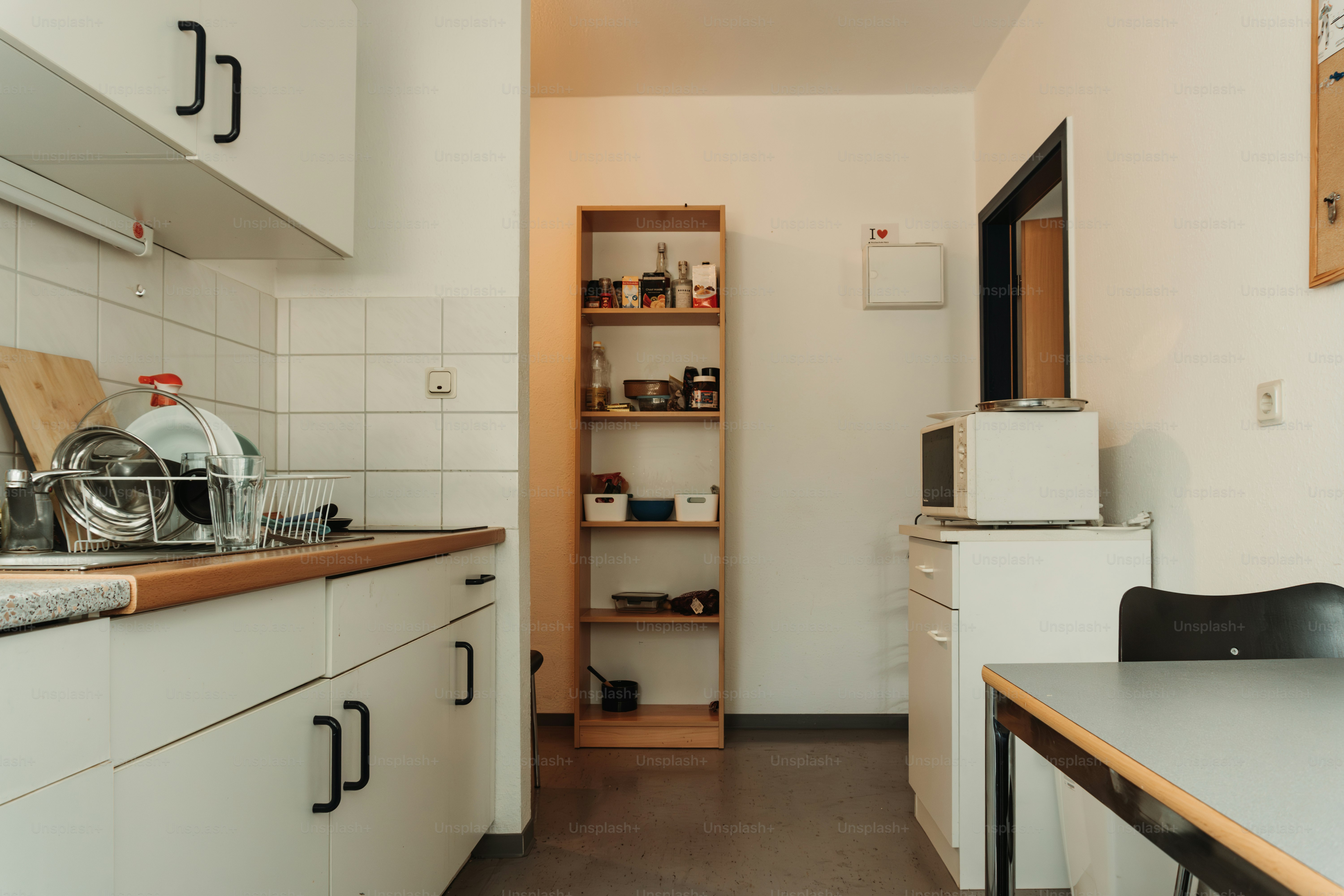 A kitchen with white cabinets and a wooden counter top