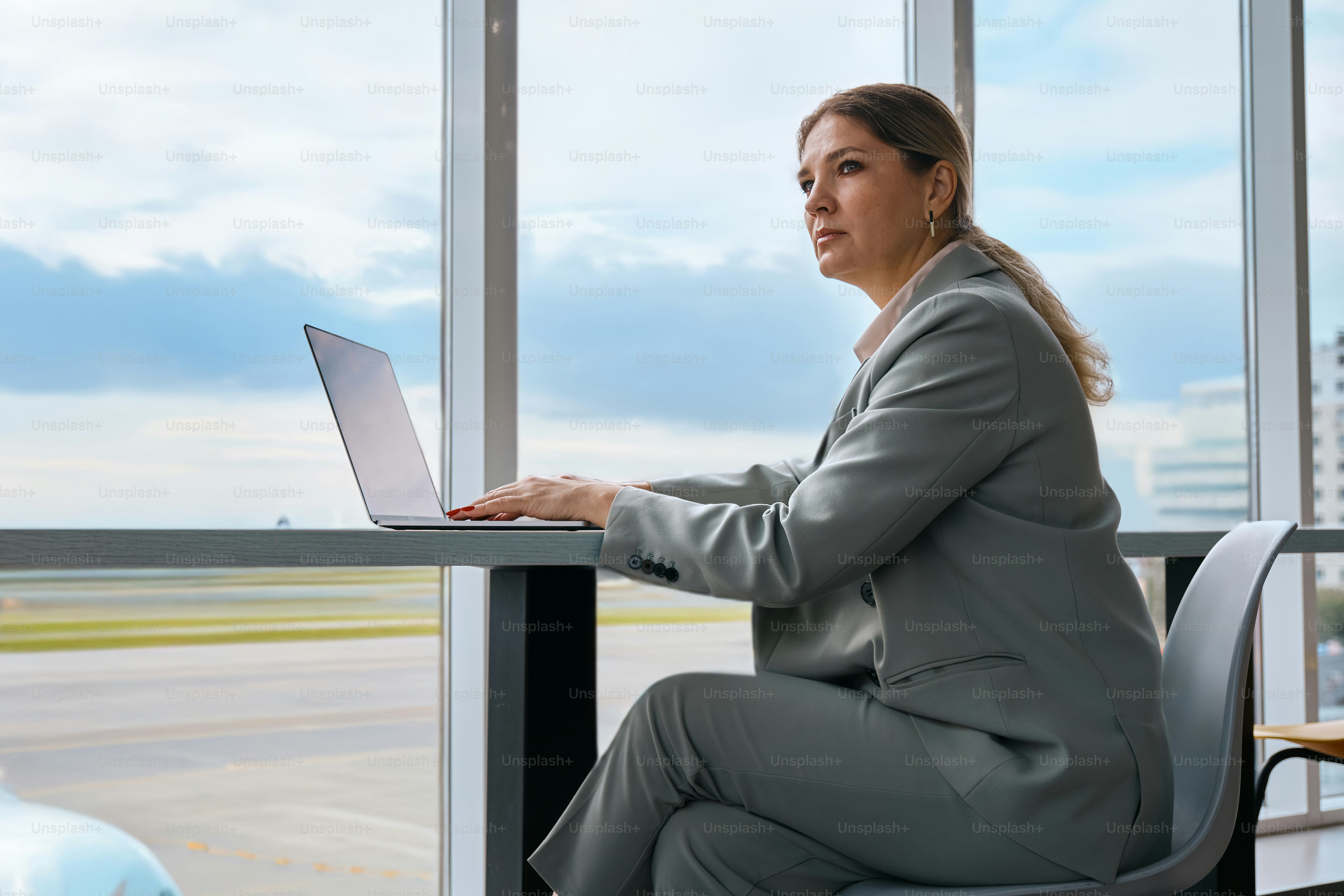 A woman sitting at a desk using a laptop computer